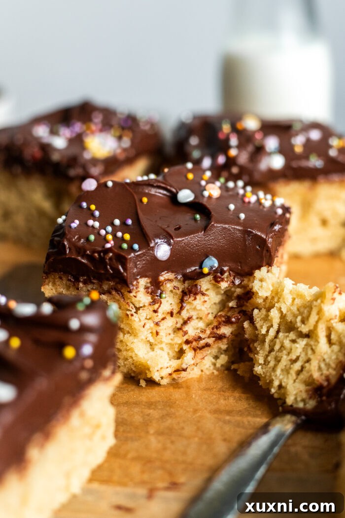 Close-up of a bitten vegan birthday cake slice on parchment paper