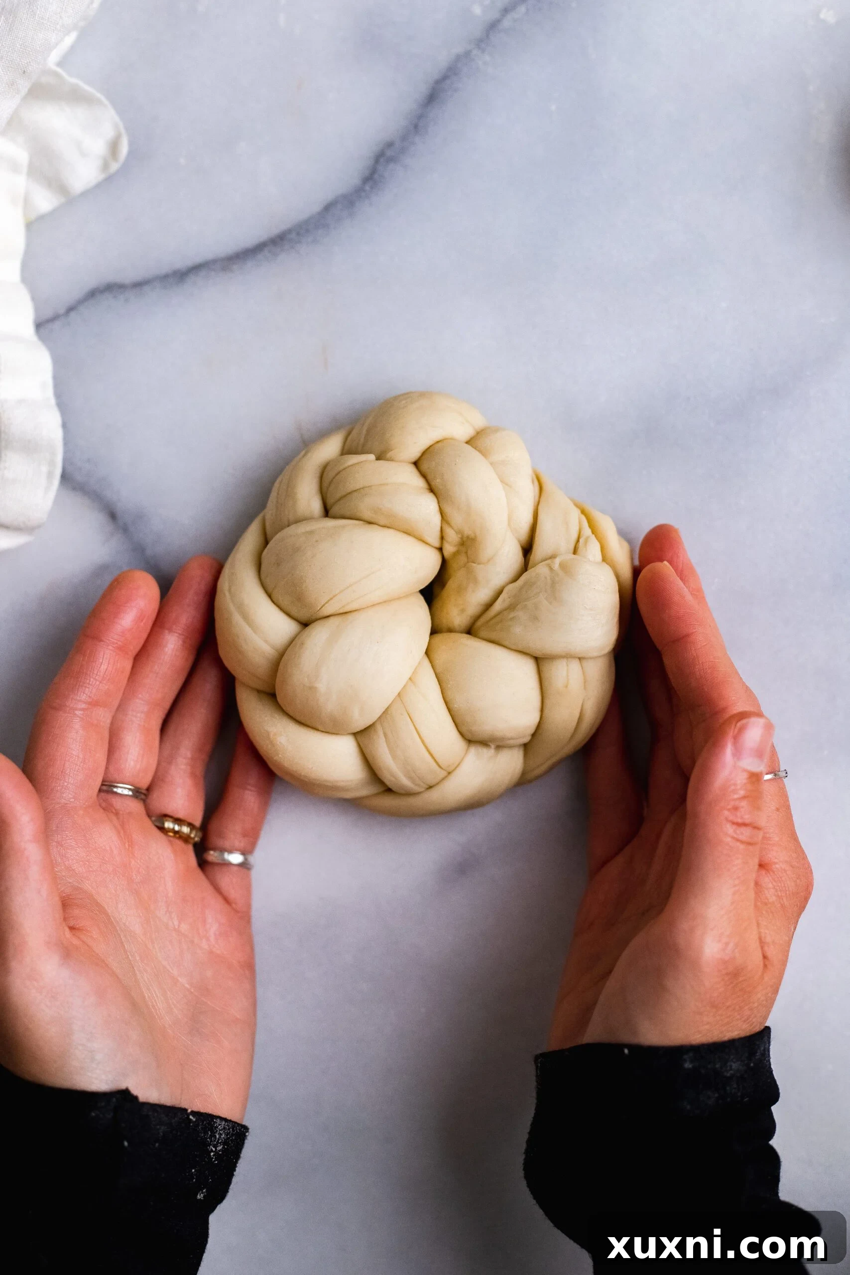 Braided vegan Easter bread dough expertly joined at the ends to form a beautiful wreath, ready for baking.