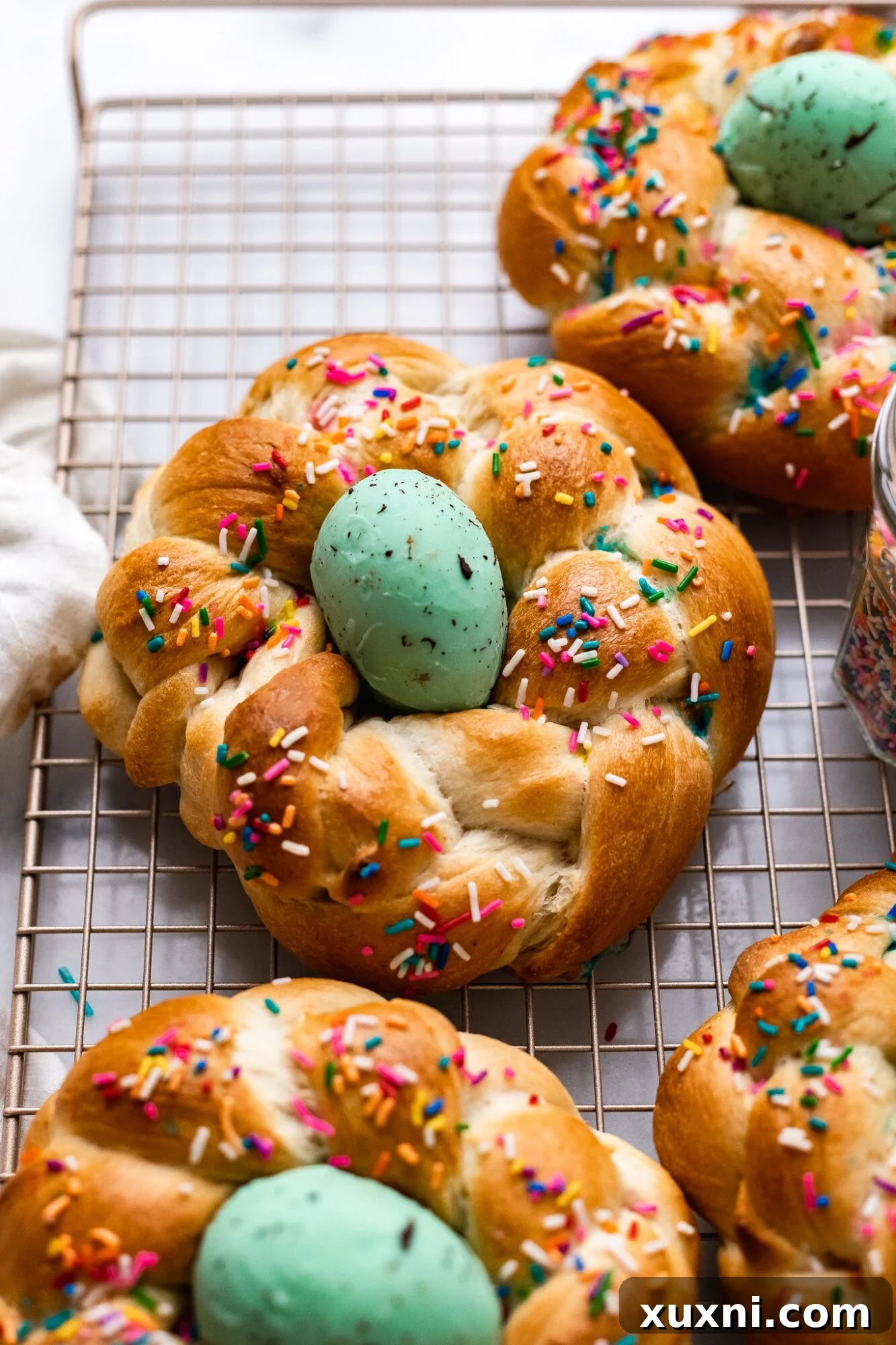 Close-up of a beautifully braided vegan Italian Easter bread, showcasing its golden crust and delicate texture on a cooling rack.