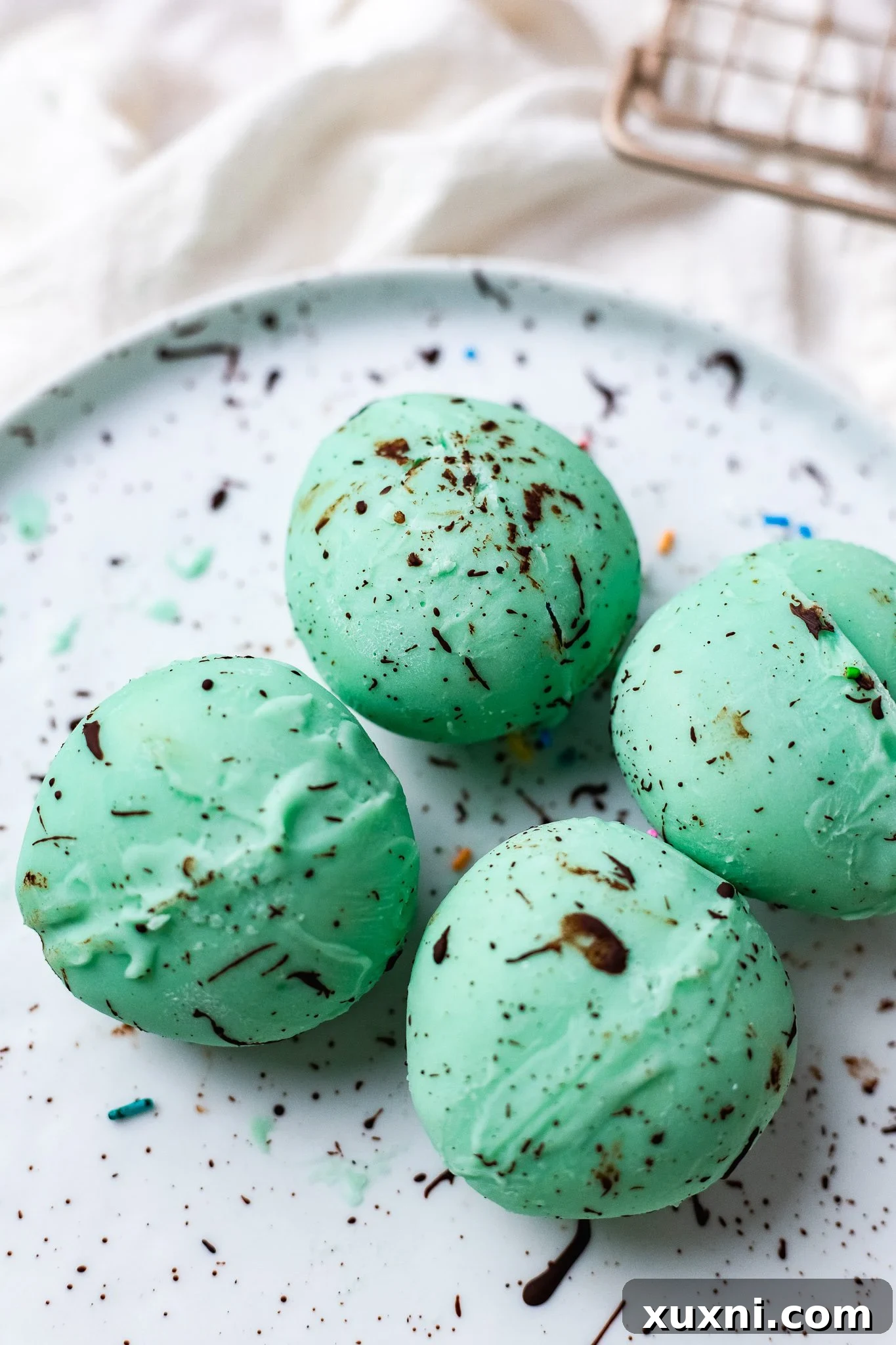 Beautifully speckled vegan white chocolate eggs, mimicking a robin's egg, ready for display.