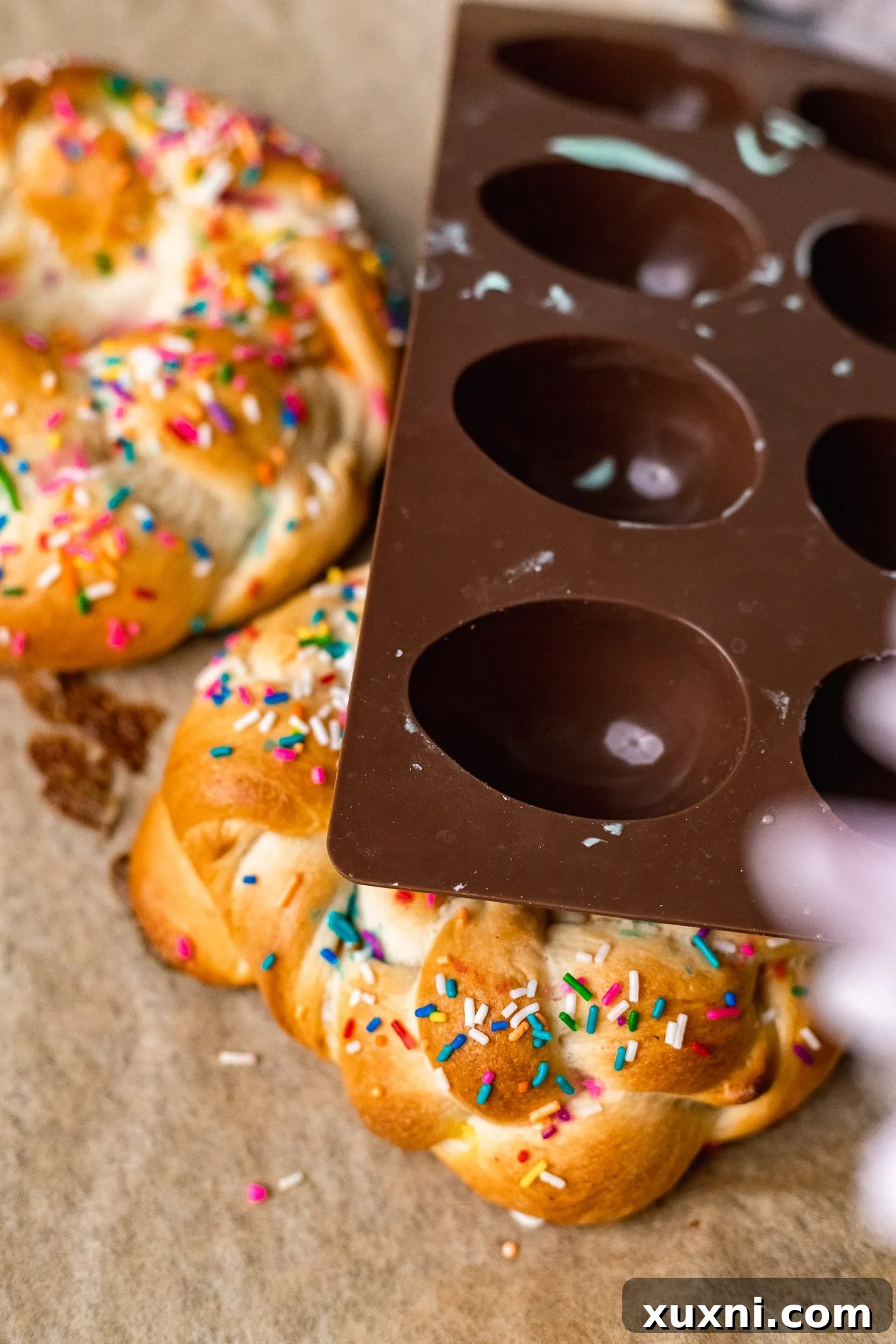 A silicone egg mold pressed into the baked bread, creating a perfect cavity for the vegan Easter egg.