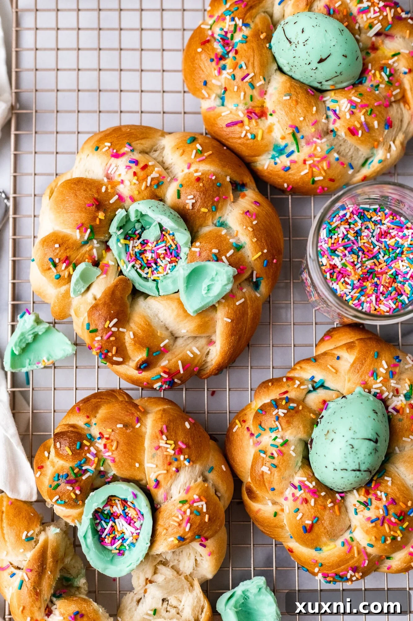 A close-up of a torn open vegan Italian Easter bread, revealing its soft, fluffy interior and a homemade vegan white chocolate egg filled with sprinkles.