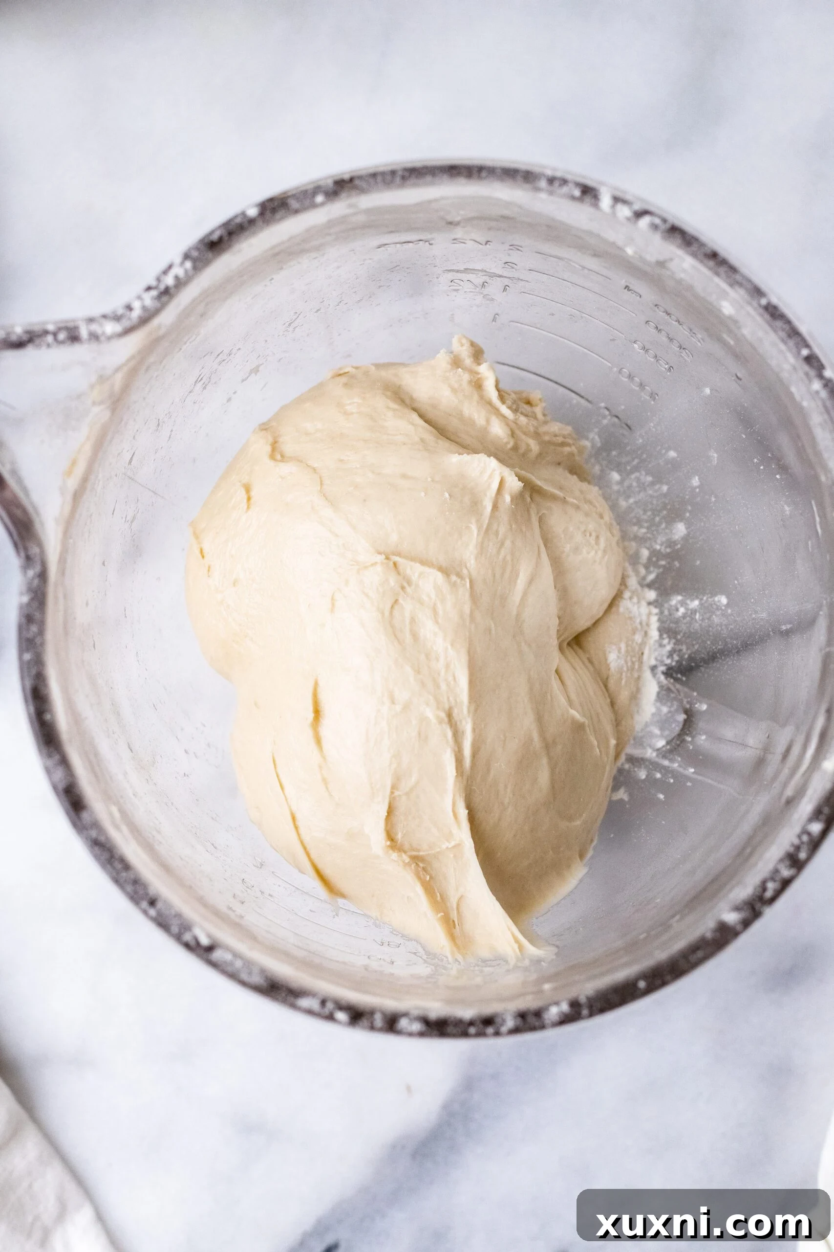 Hands actively kneading vegan Italian Easter bread dough, showing the process of combining ingredients for a smooth consistency.