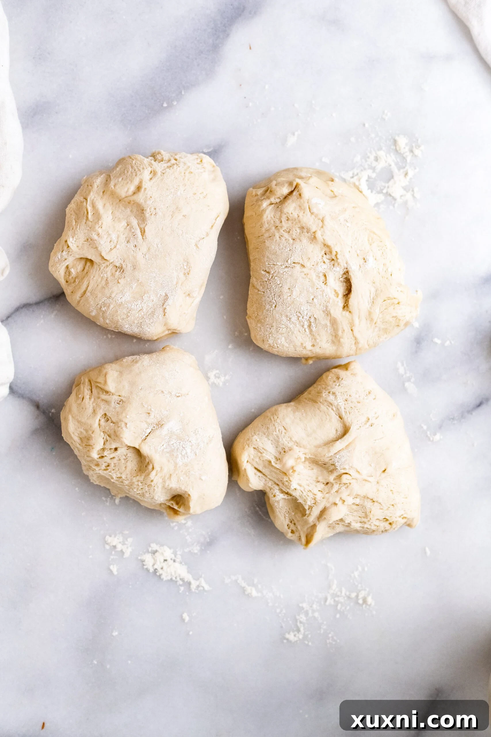 Vegan Italian Easter bread dough divided into four equal portions, prepared for shaping into individual loaves.