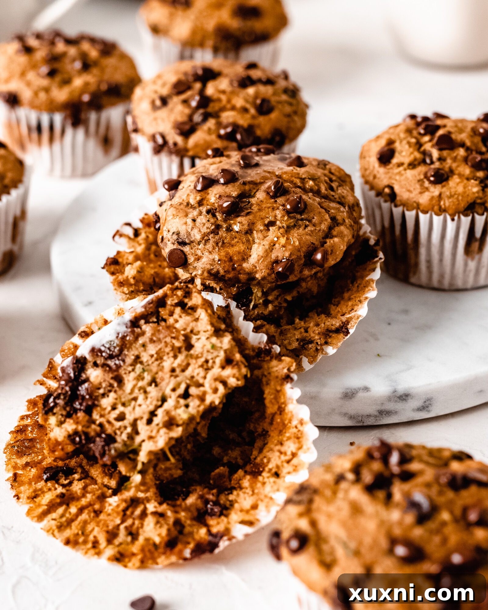 A freshly baked batch of healthy vegan zucchini muffins cooling on a wire rack.