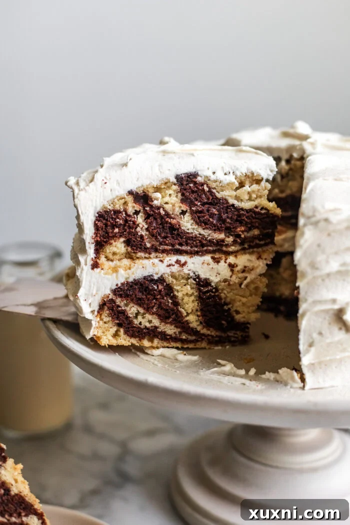 Sliced vegan zebra cake displaying beautiful chocolate and vanilla swirls.