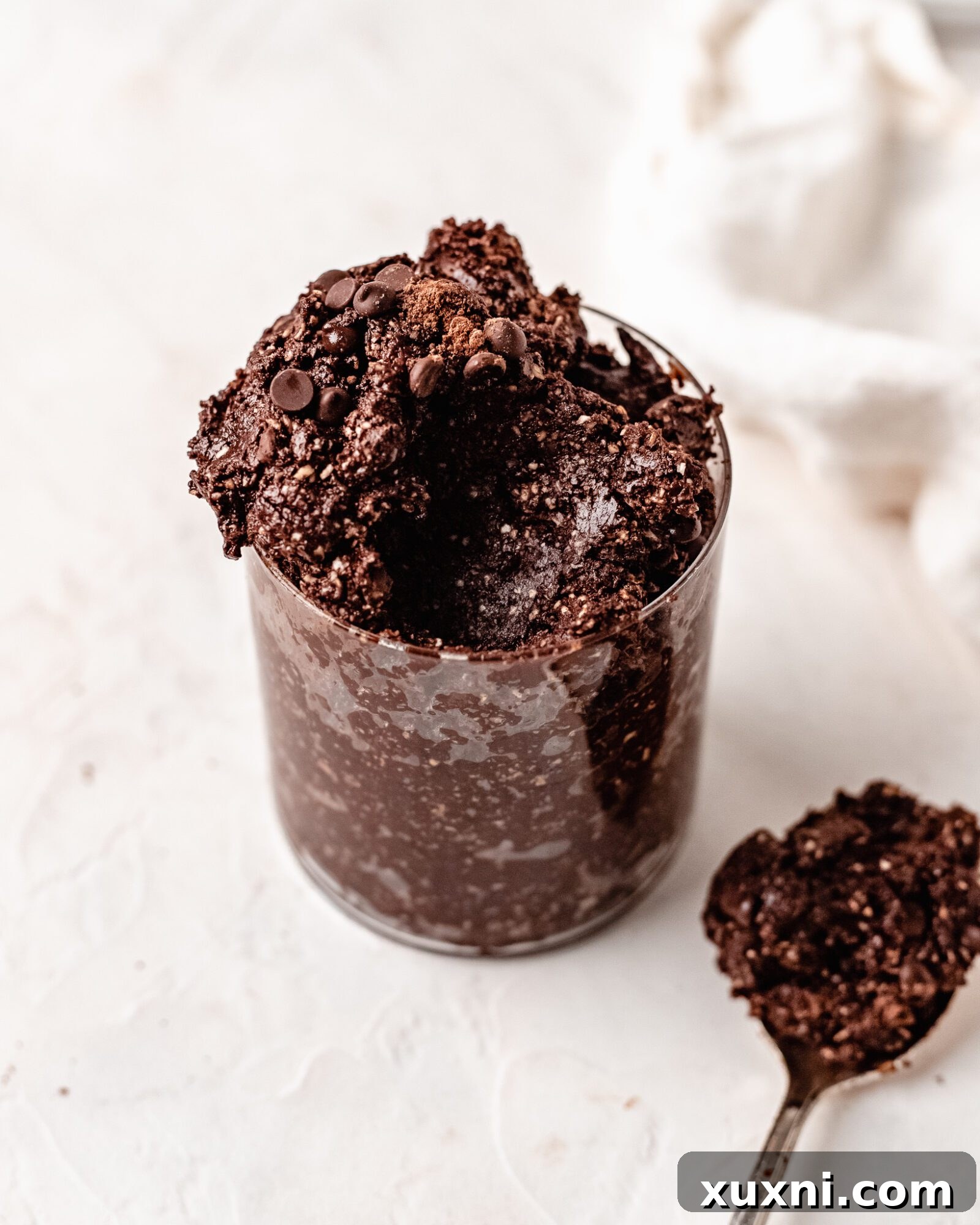 A spoonful of rich, dark edible brownie batter, showcasing its thick and fudgy texture.
