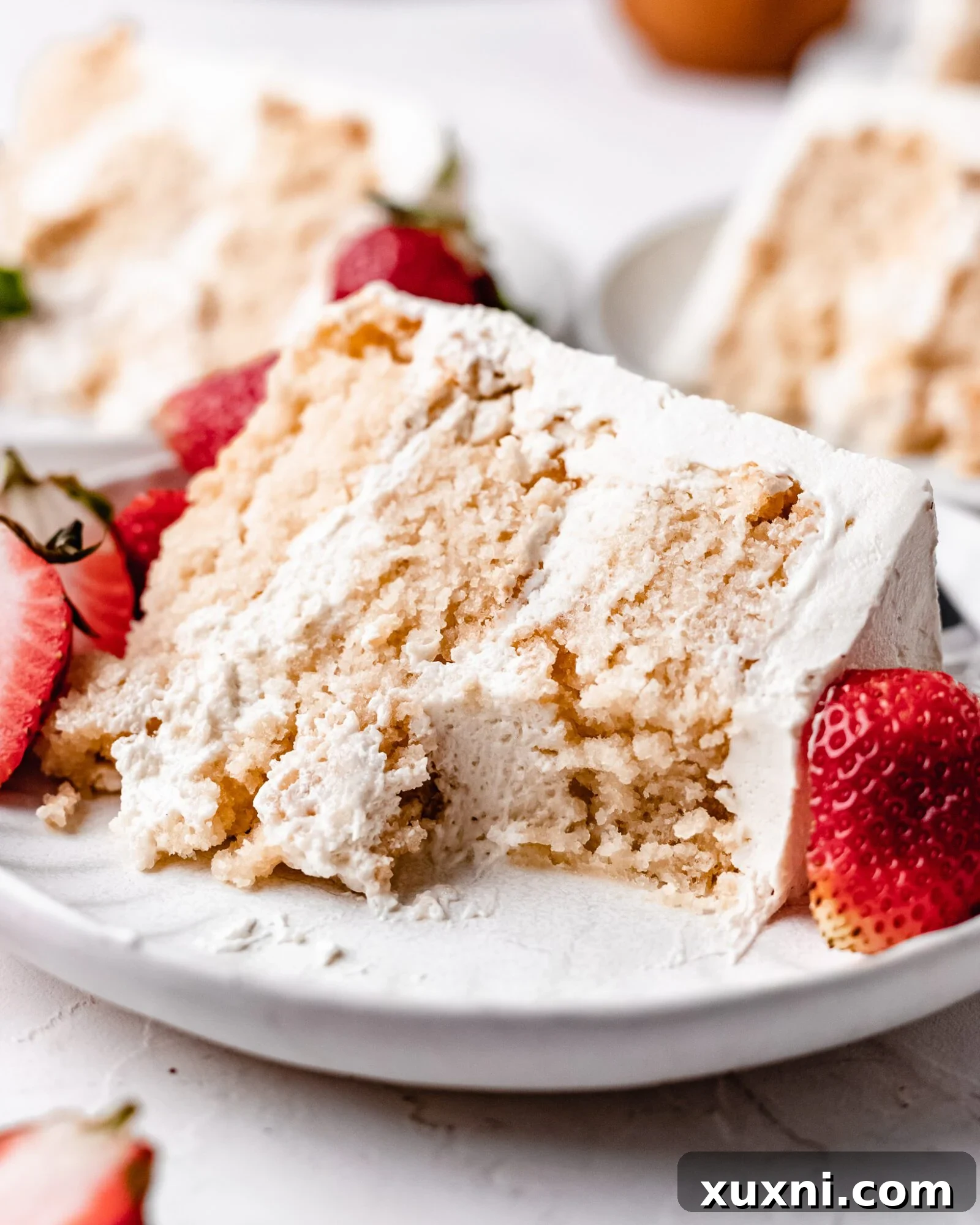 A close-up of a generous slice of Strawberry Vanilla Chiffon Cake, showcasing its beautiful crumb and luscious frosting.