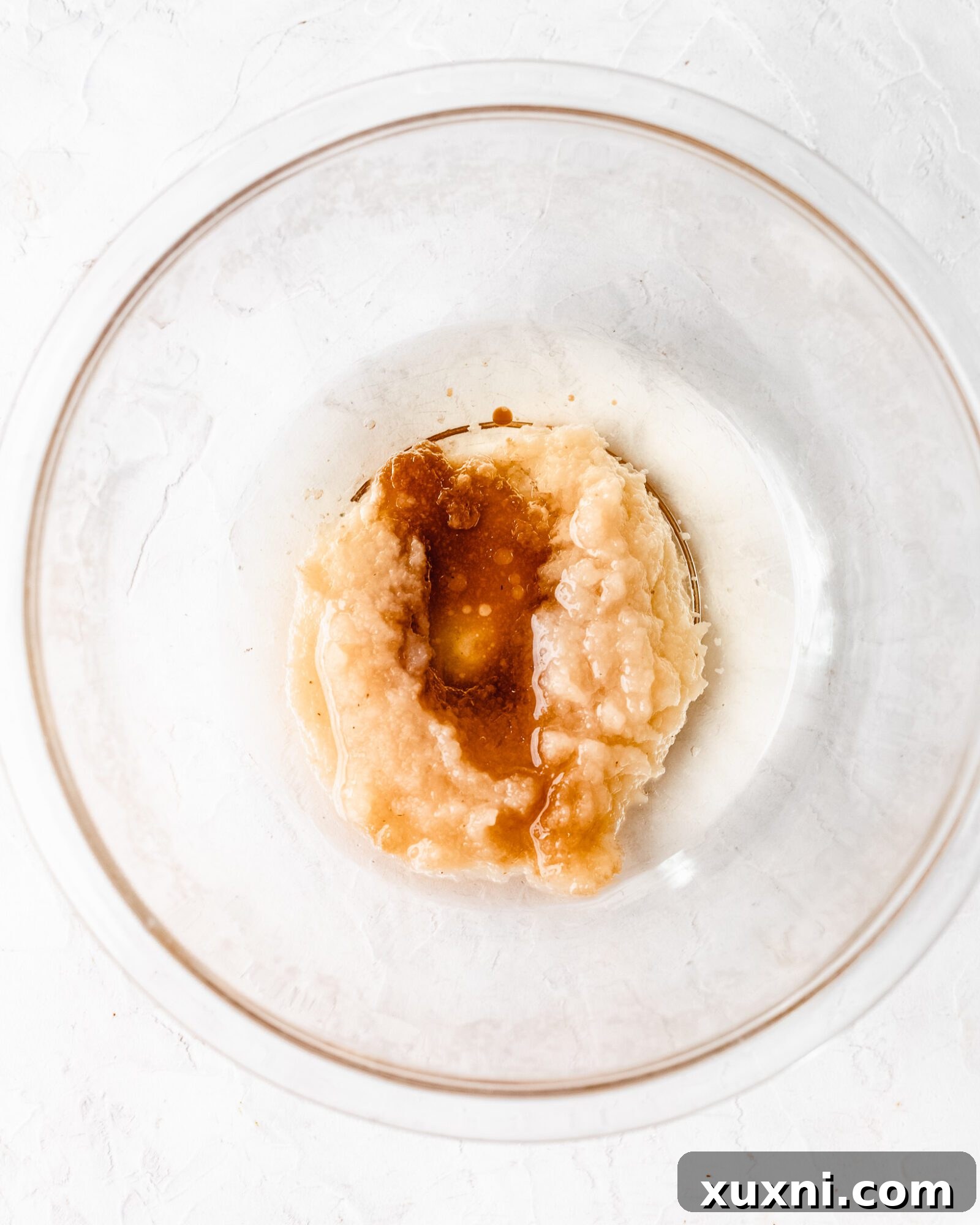 Bowl of wet ingredients for vegan chiffon cake, including dairy-free milk, oil, applesauce, and vanilla extract.