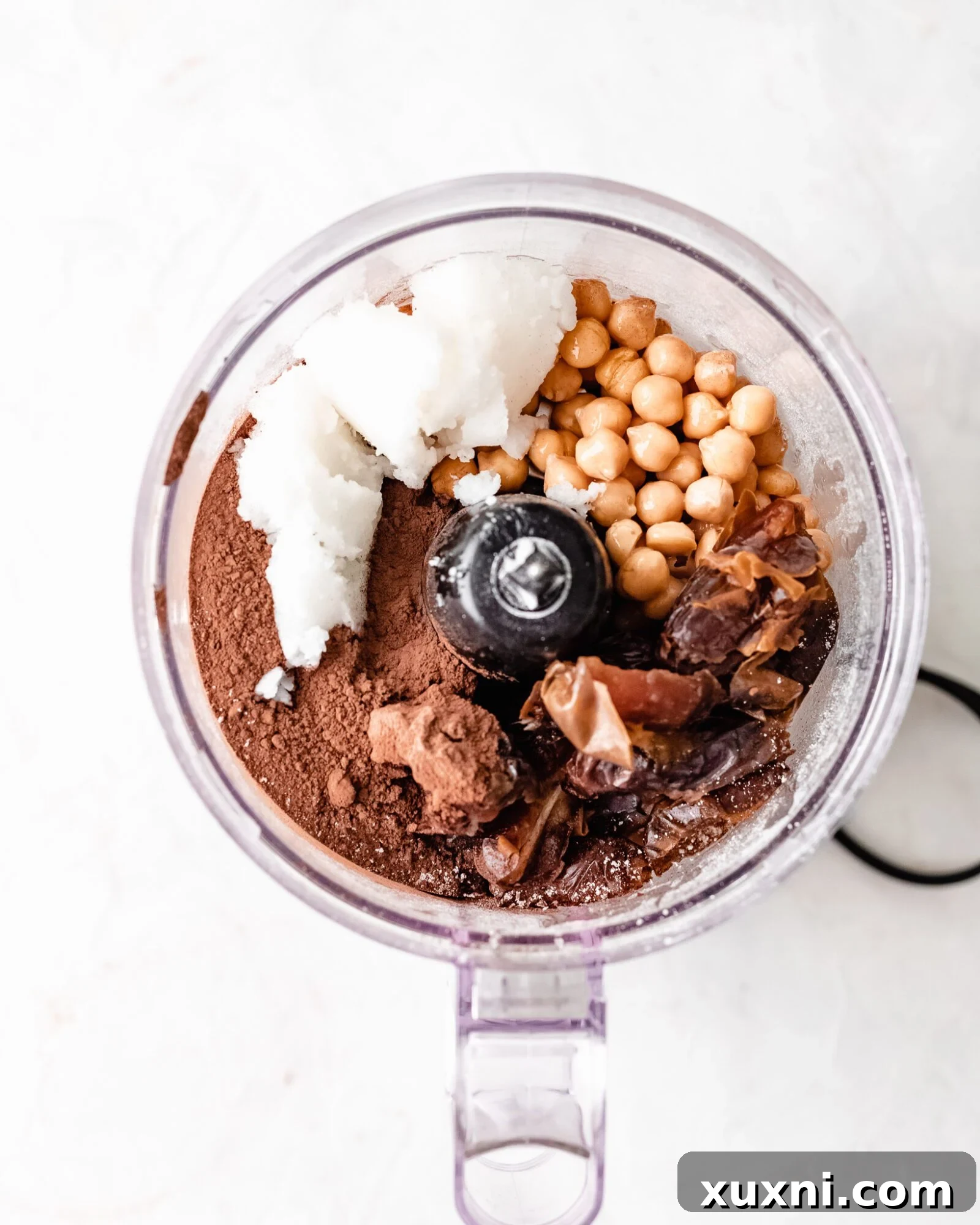 Ingredients laid out for making healthy no-bake vegan brownies, showcasing fresh dates, chickpeas, oats, and cacao powder.