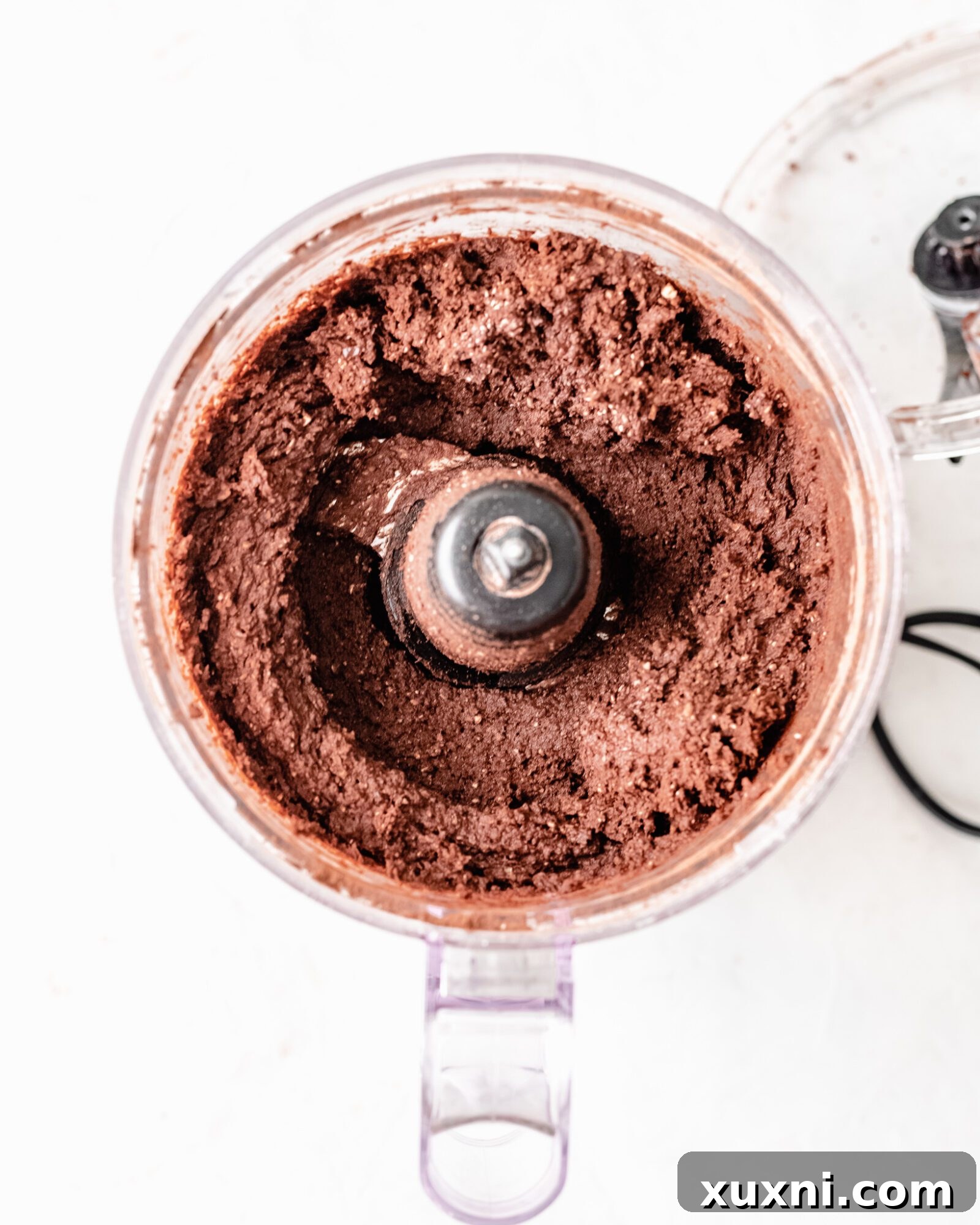 The smooth, rich batter for no-bake brownies in a food processor, ready to be pressed into the pan.