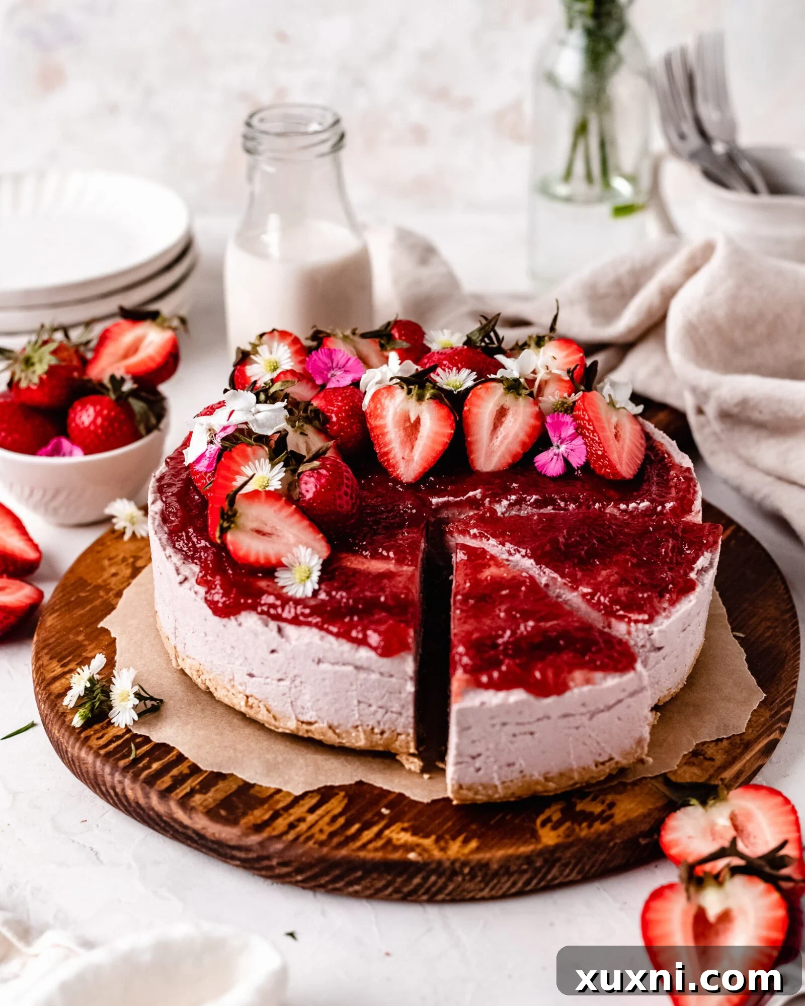 Sliced creamy no-bake vegan strawberry cheesecake garnished with fresh strawberries