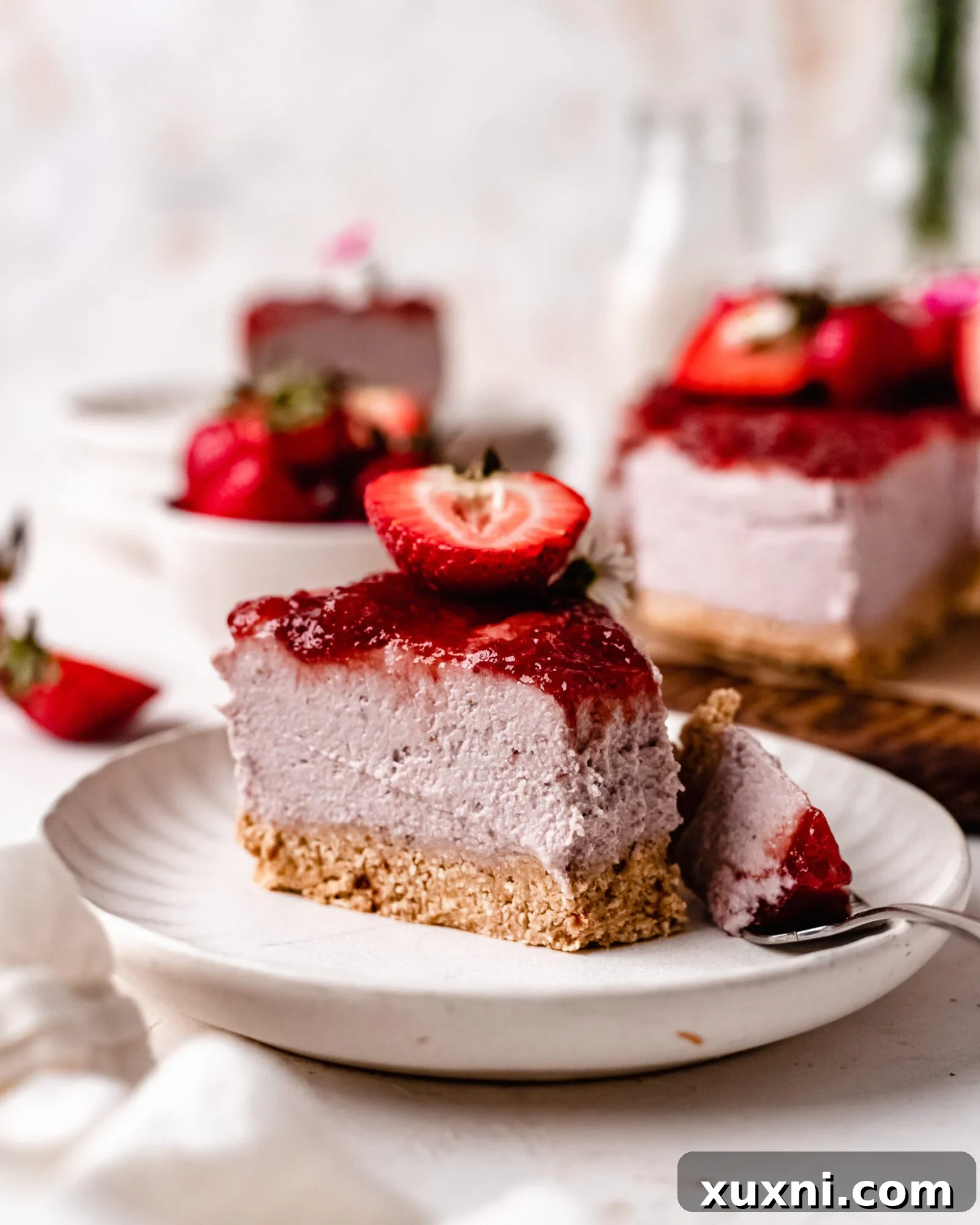 A vibrant slice of vegan strawberry cheesecake on a plate, ready to be enjoyed