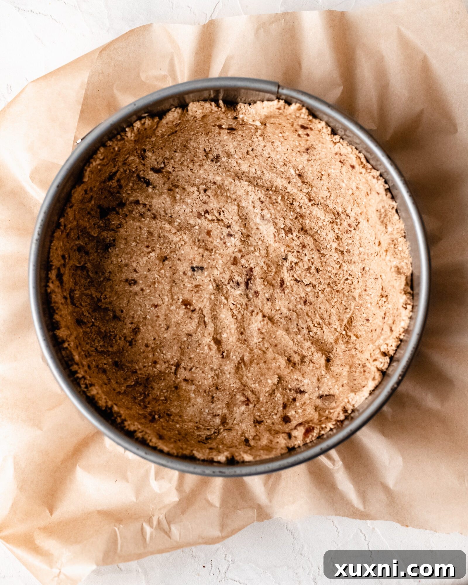 The pressed vegan oat crust in a springform pan