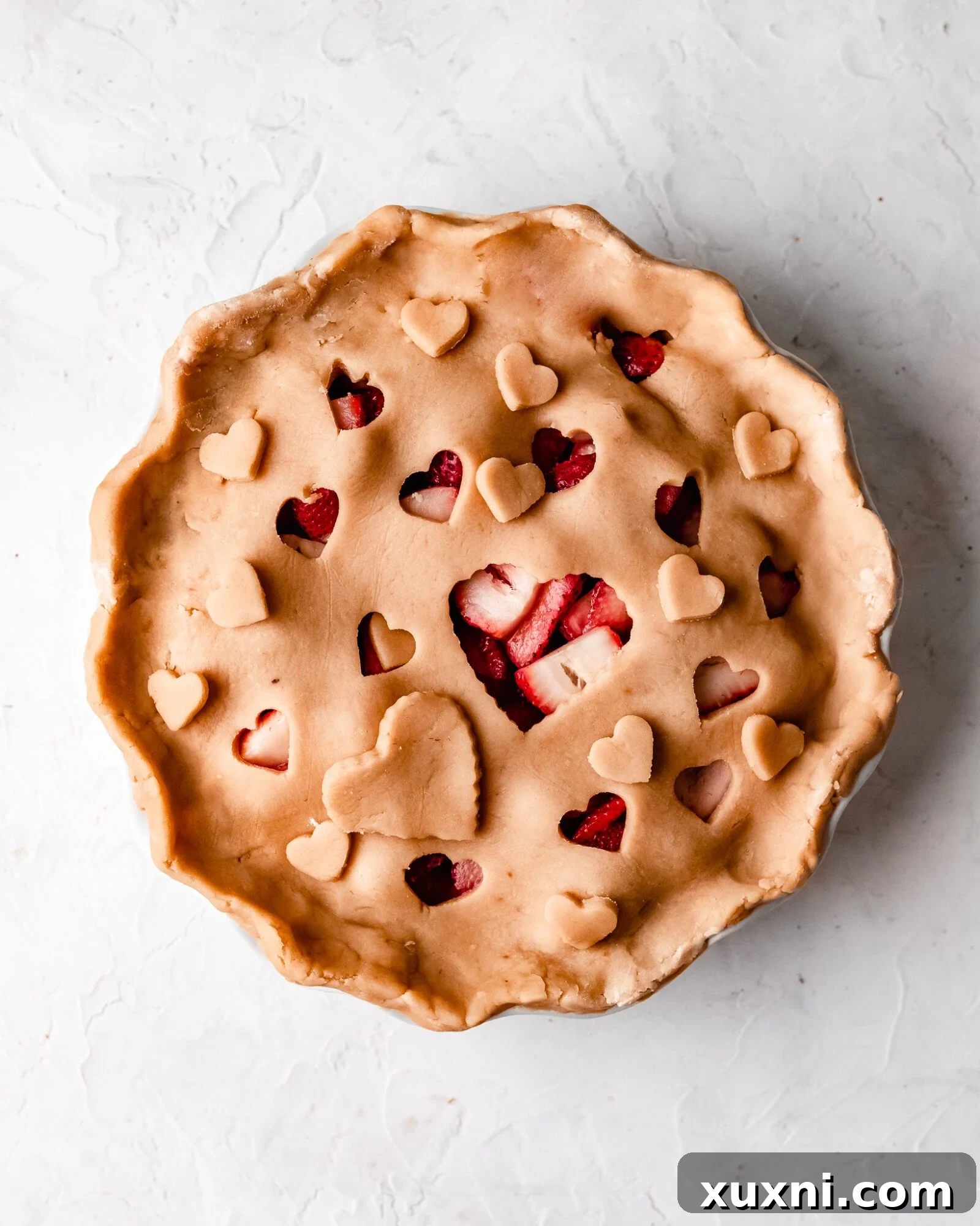 A whole vegan strawberry pie, baked to golden perfection, ready to be sliced.