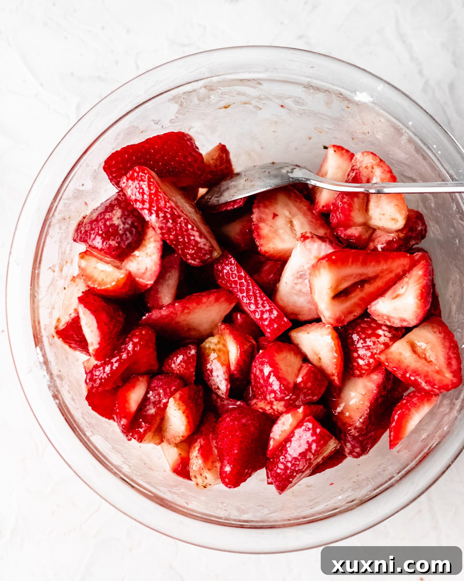 Freshly sliced strawberries mixed with starch and lemon juice, ready for the pie crust.