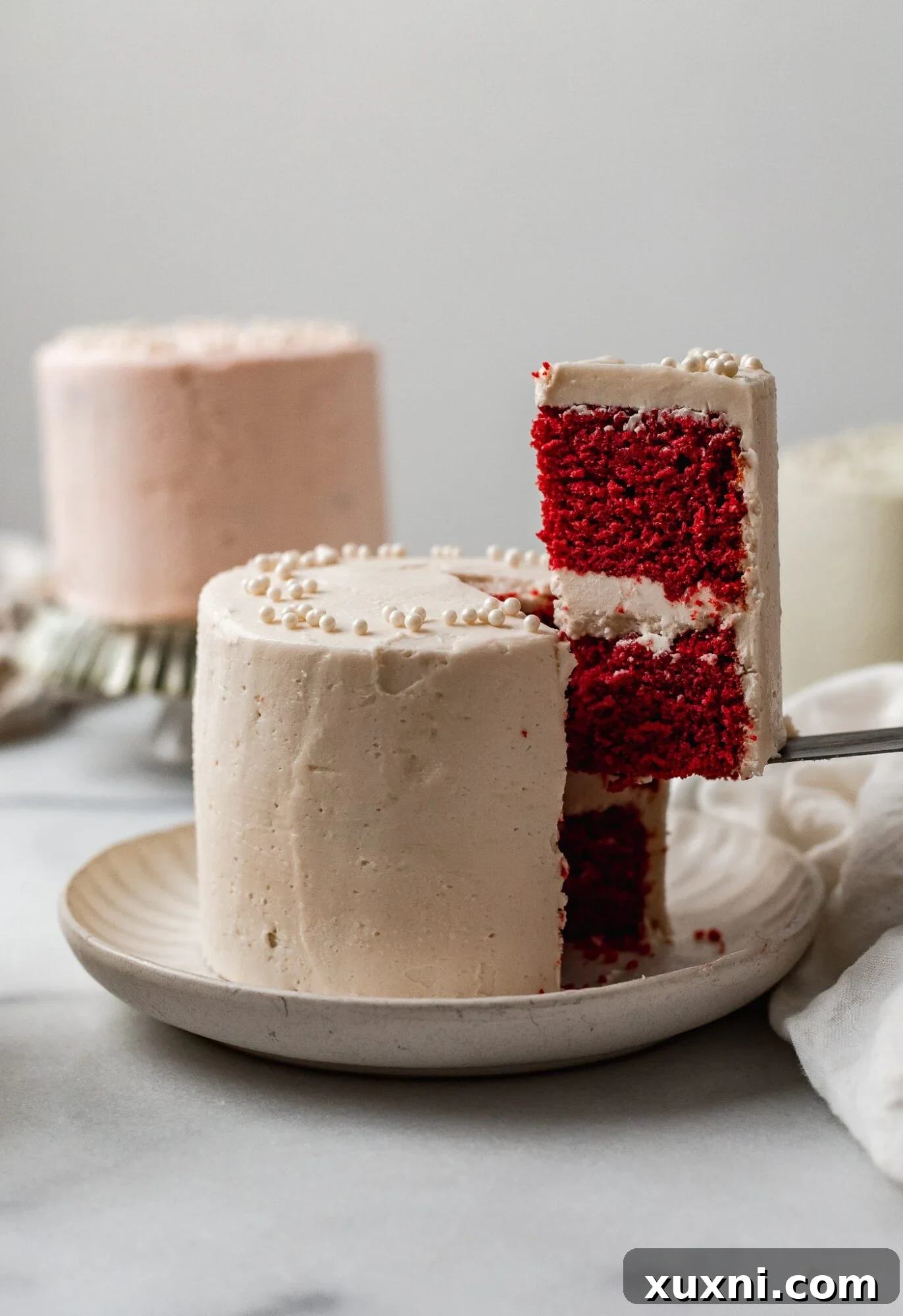 A slice of vegan mini cake revealing its perfectly baked layers and creamy frosting inside.