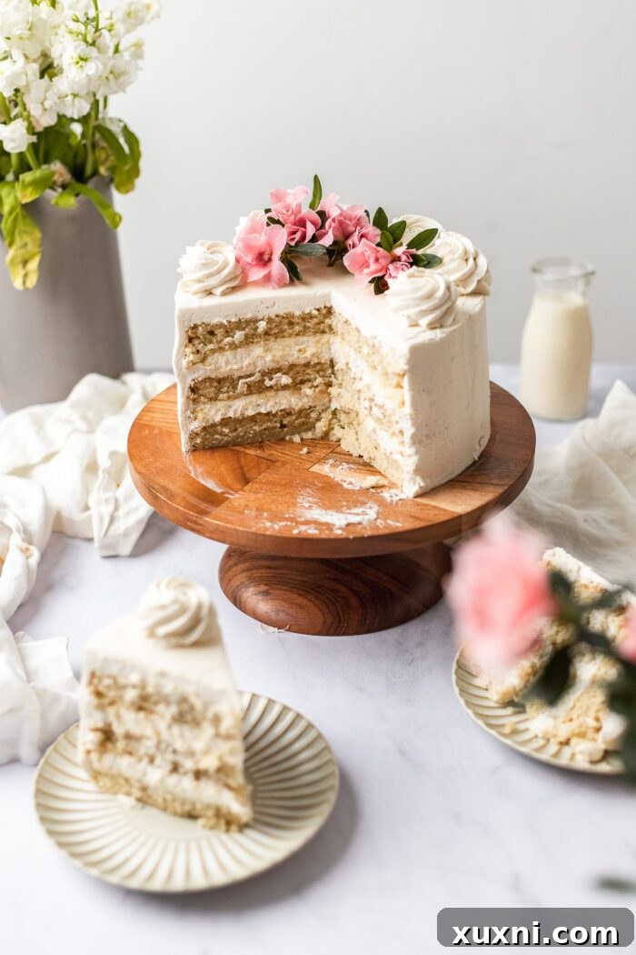 35 Delicious Vegan Cake Recipes Everyone Will Love 3 A slice of moist vegan vanilla cake on a wooden cake stand, surrounded by extra slices on white plates