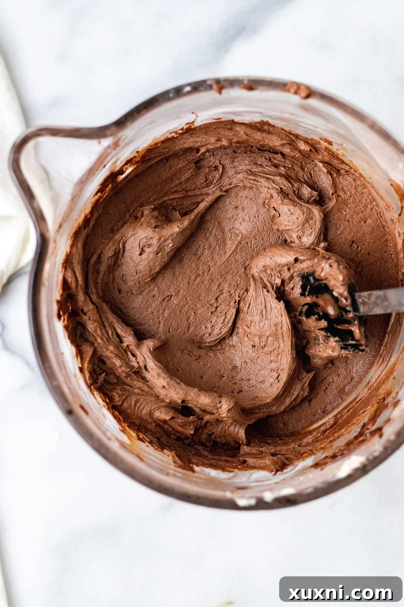 35 Delicious Vegan Cake Recipes Everyone Will Love 5 A bowl of rich, smooth vegan chocolate frosting, ready to be spread on a delicious cake