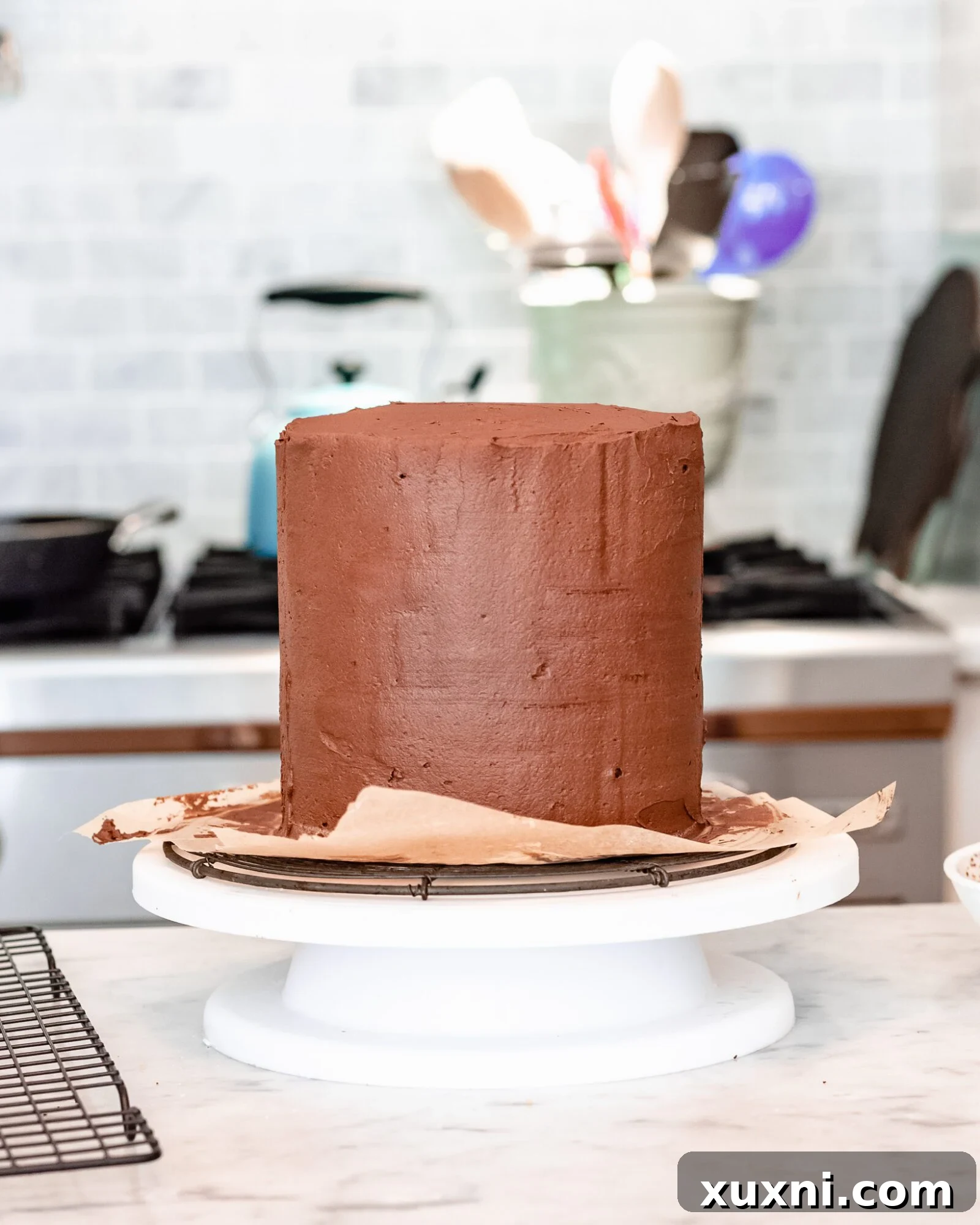 Creamy chocolate frosting being spread, indicating readiness for cake application