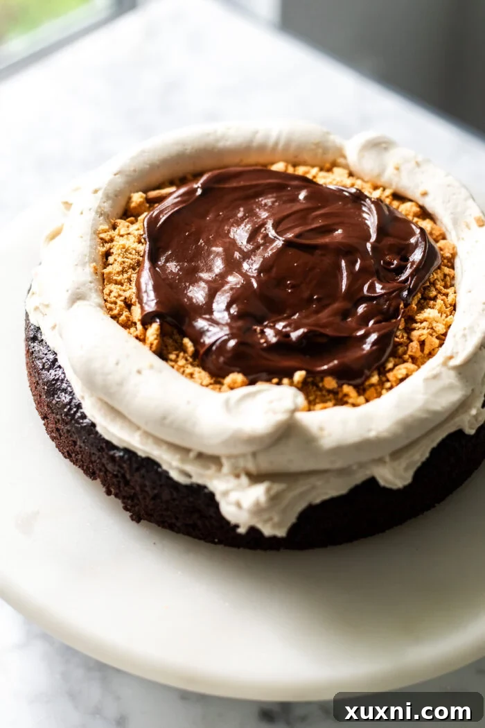 Close-up of the s'mores cake assembly, showing layers being built