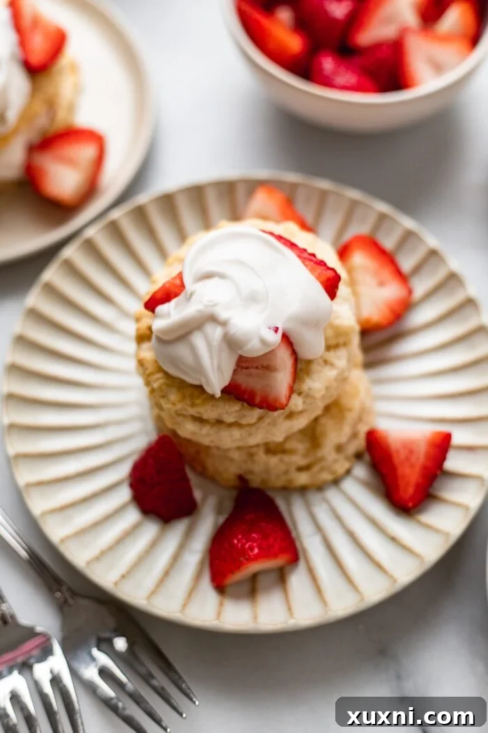 strawberry shortcake on a plate next to a bowl of strawberries