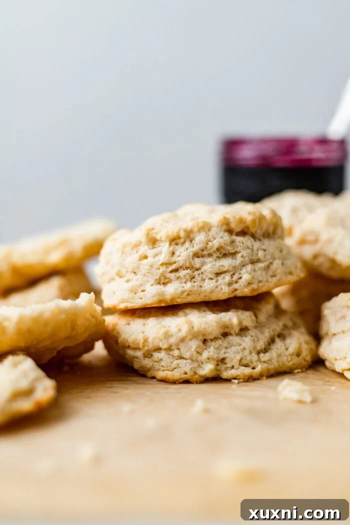 a stack of freshly baked vegan buttermilk biscuits on parchment paper