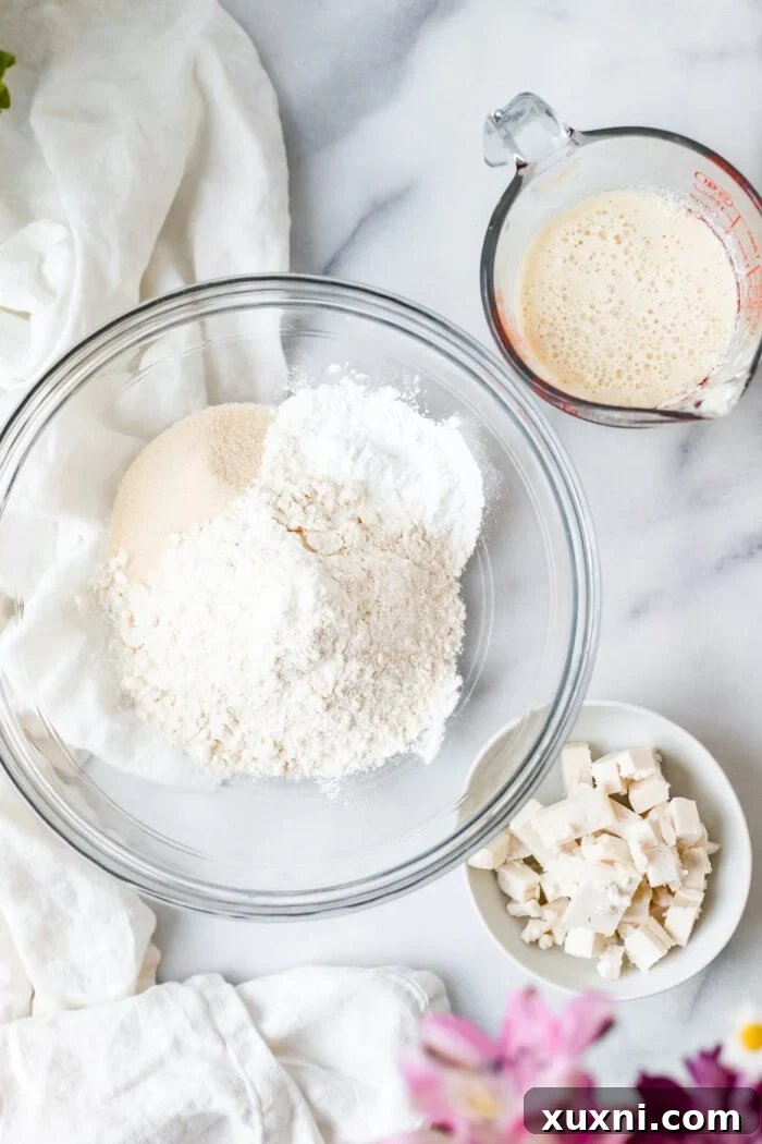 individual ingredients for vegan biscuits laid out on a marble surface