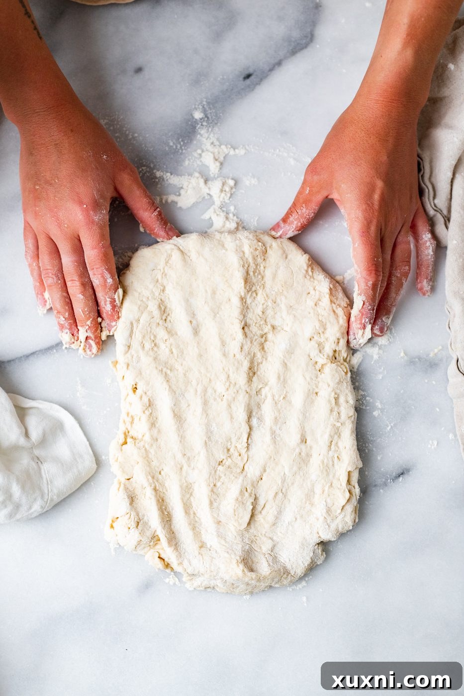 hands gently shaping vegan biscuit dough