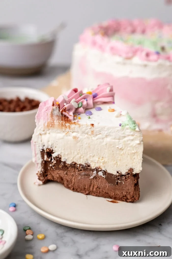 Effortless Plant-Based Gluten-Free Ice Cream Cake 2 A beautifully sliced piece of vegan ice cream cake on a white plate, showcasing its distinct layers of chocolate ice cream, hot fudge, crunchy cacao crisps, and vanilla ice cream.