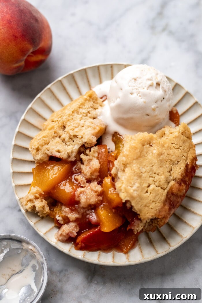 plate of Vegan peach cobbler with a scoop of ice cream