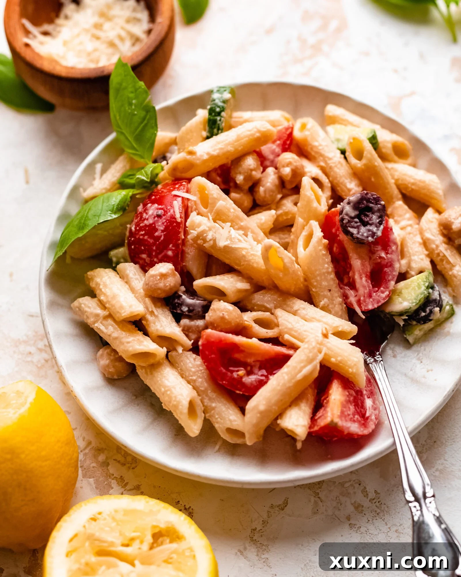 plate of vegan pasta salad - A single serving of creamy vegan pasta salad on a plate, garnished with fresh basil, ready to be enjoyed.
