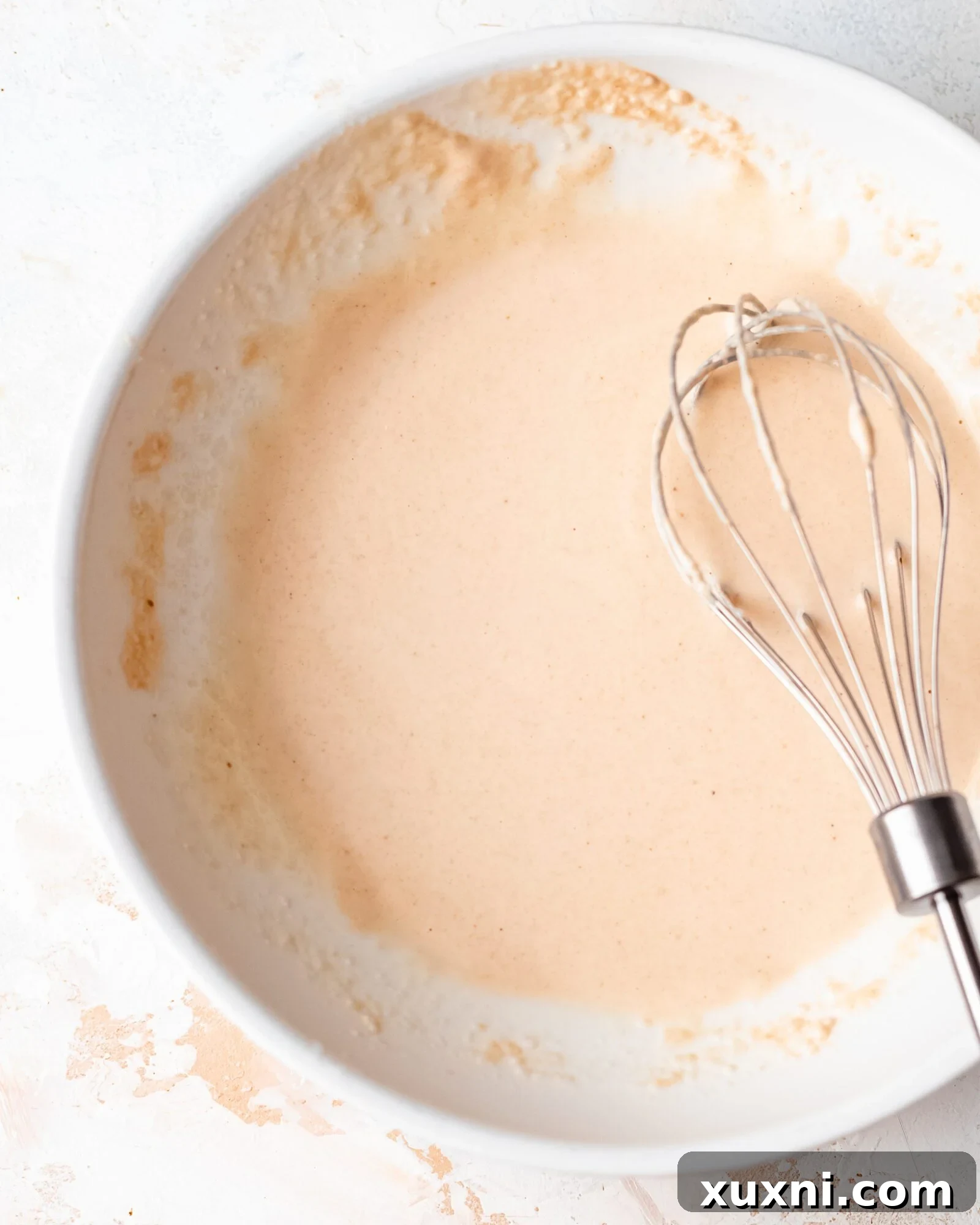 lemon tahini dressing mixed - A small bowl filled with creamy, light-colored lemon tahini dressing after whisking, ready for the pasta salad.