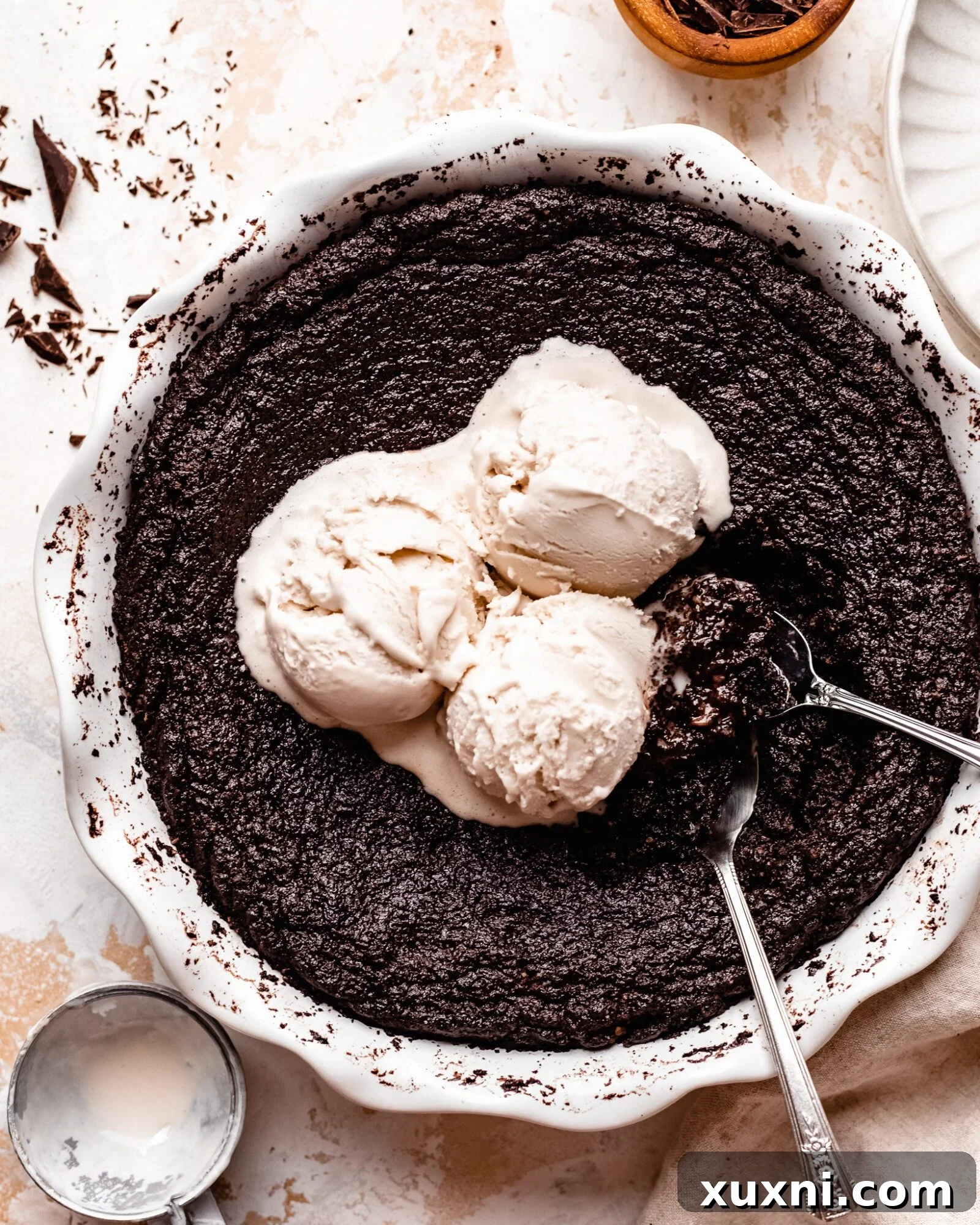 Scoops of dairy-free ice cream melting on a warm skillet brownie.