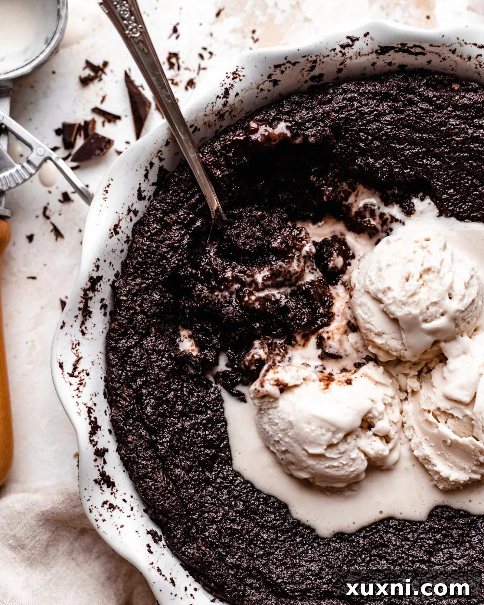 skillet brownie being served with ice cream scoops on top, showcasing its gooey texture.