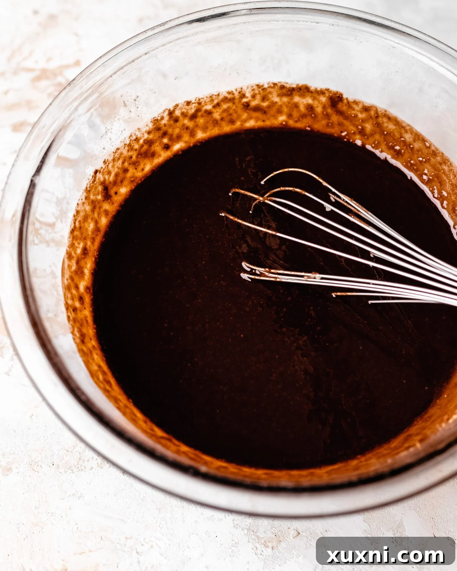 Coconut sugar and applesauce being whisked into the brownie batter.