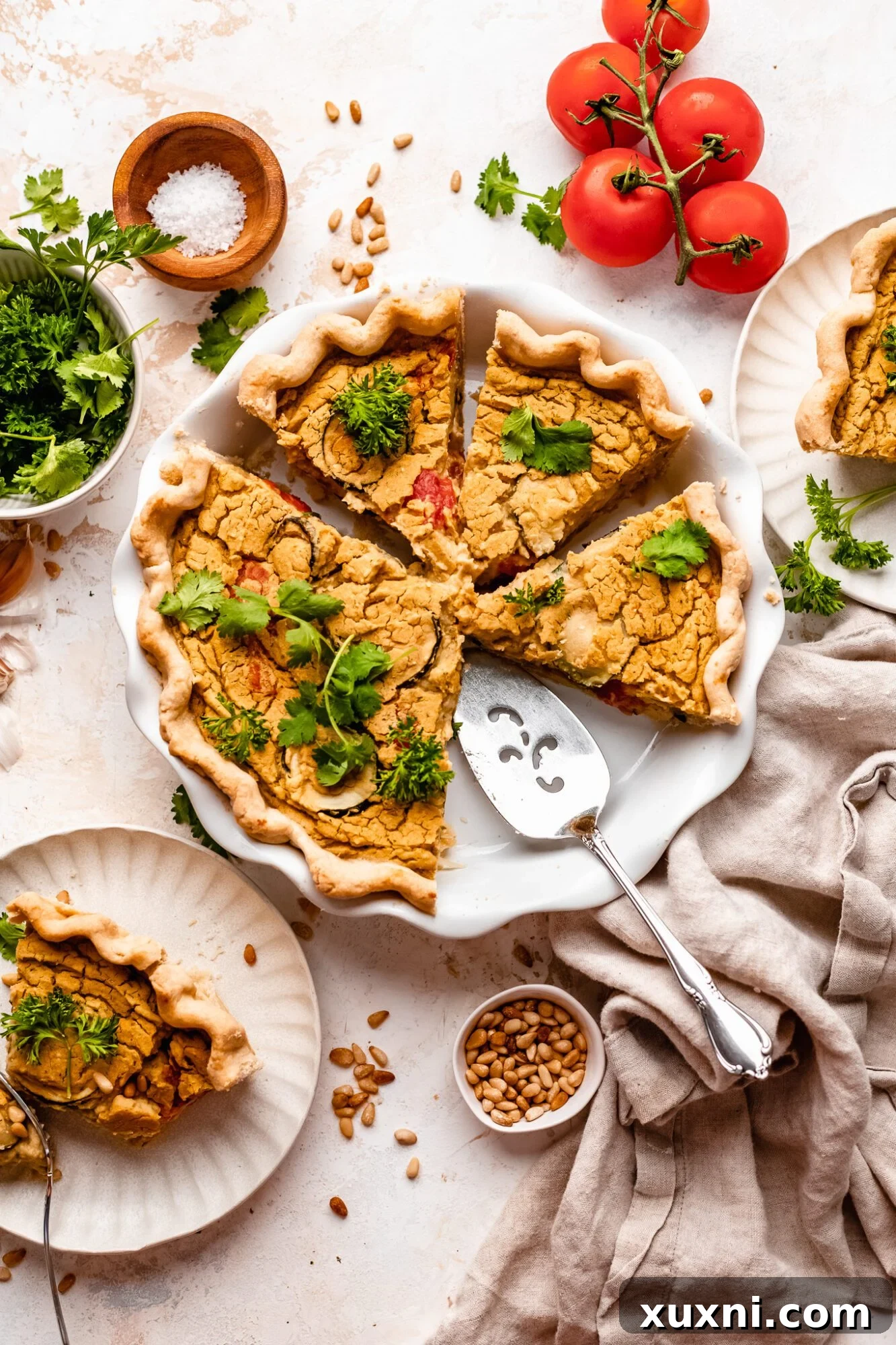Sliced Vegan Quiche on a serving plate with fresh herbs