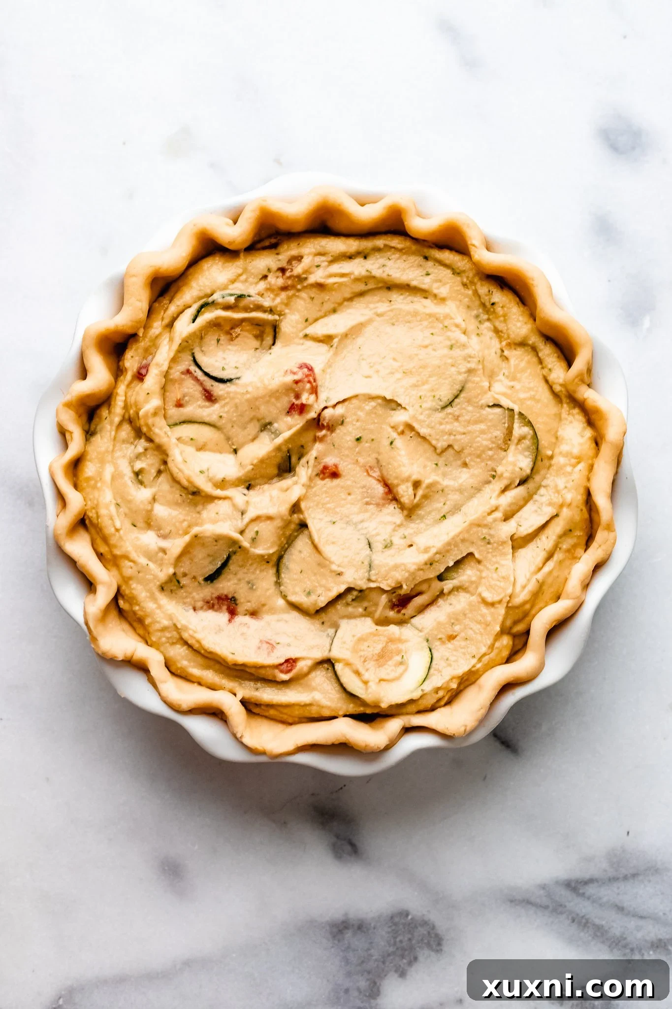 vegan quiche before baking, with filling poured into crust