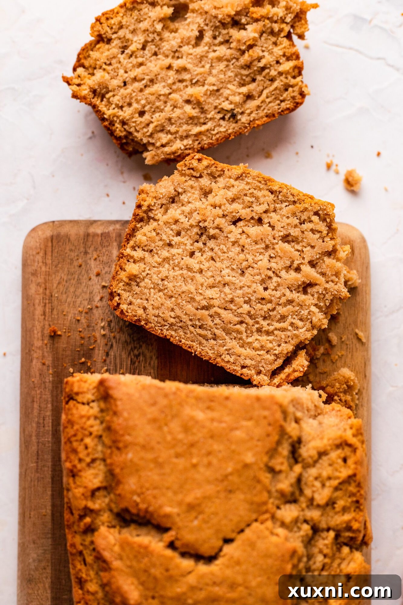 Golden-brown vegan vanilla pound cake, freshly baked and ready to be cubed.