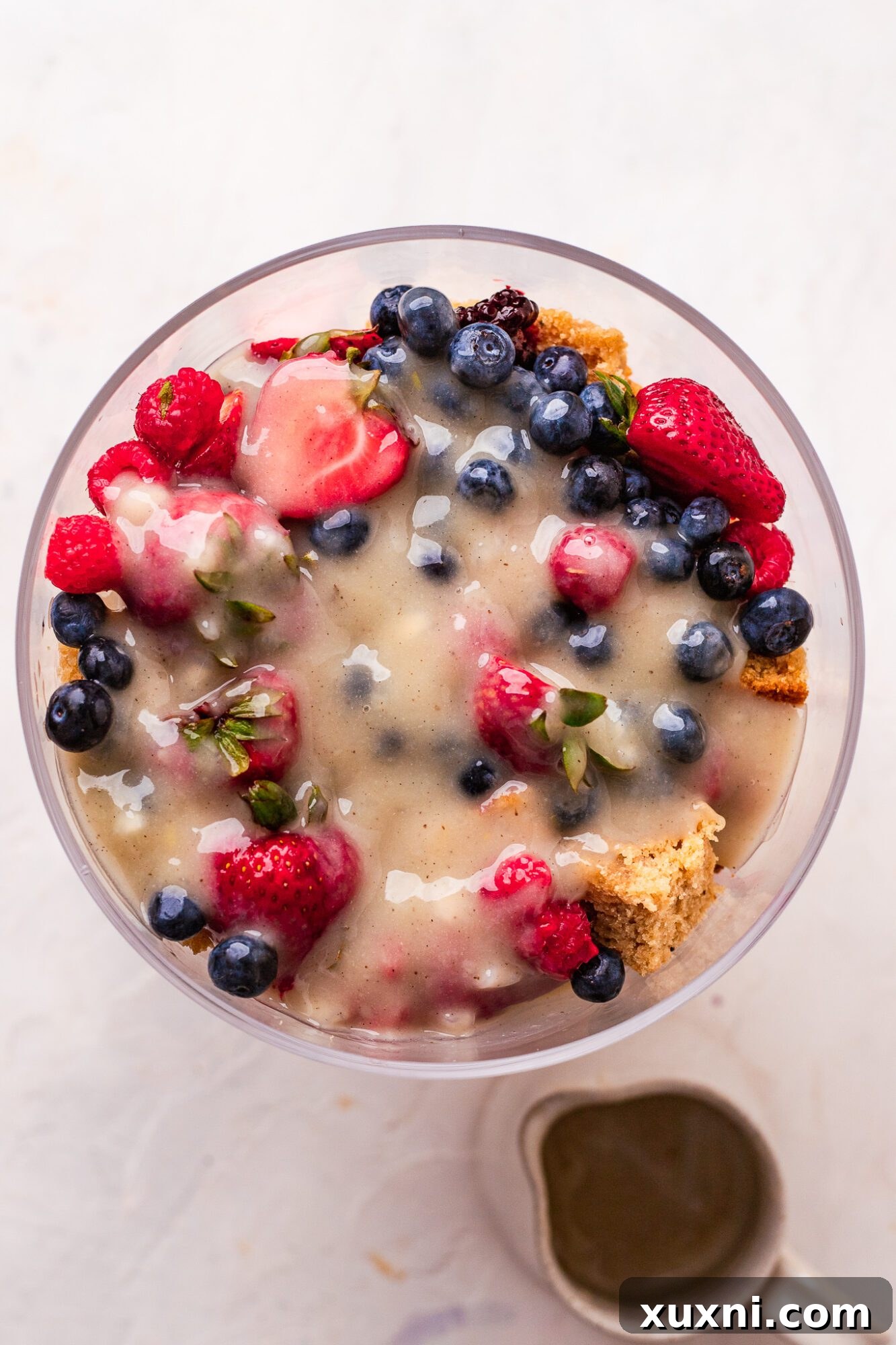 A close-up side view of the assembled vegan lemon berry trifle, showing the distinct and colorful layers.