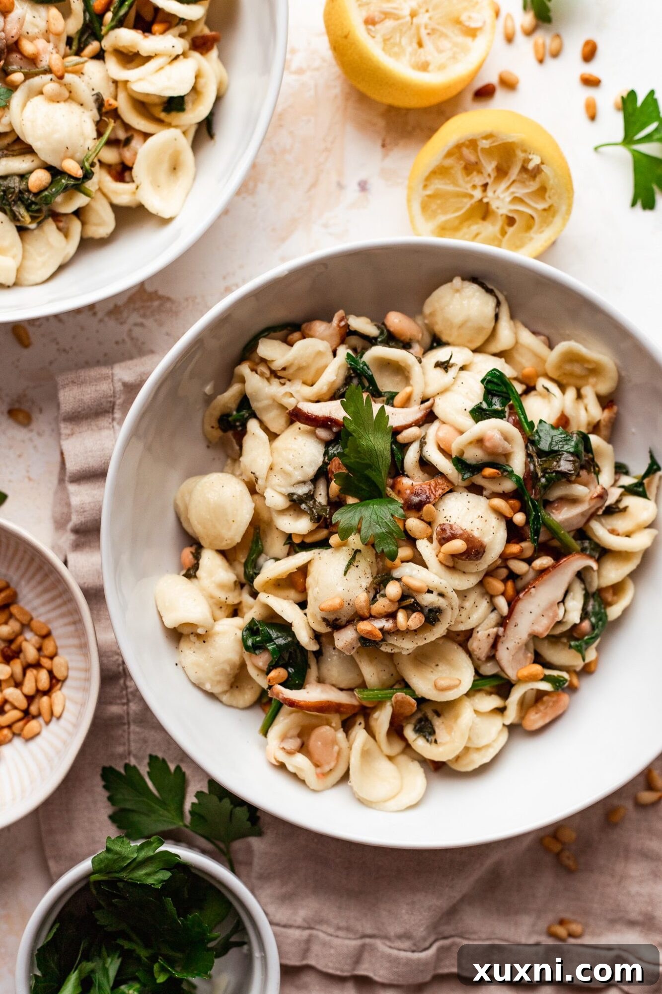 Velvety Vegan Mushroom and Spinach Pasta 2 A vibrant bowl of creamy vegan mushroom and spinach pasta, garnished with fresh herbs and pine nuts, ready to be enjoyed.