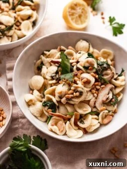 A close-up shot of creamy vegan mushroom pasta, ready to be served, highlighting its rich texture and fresh garnish.