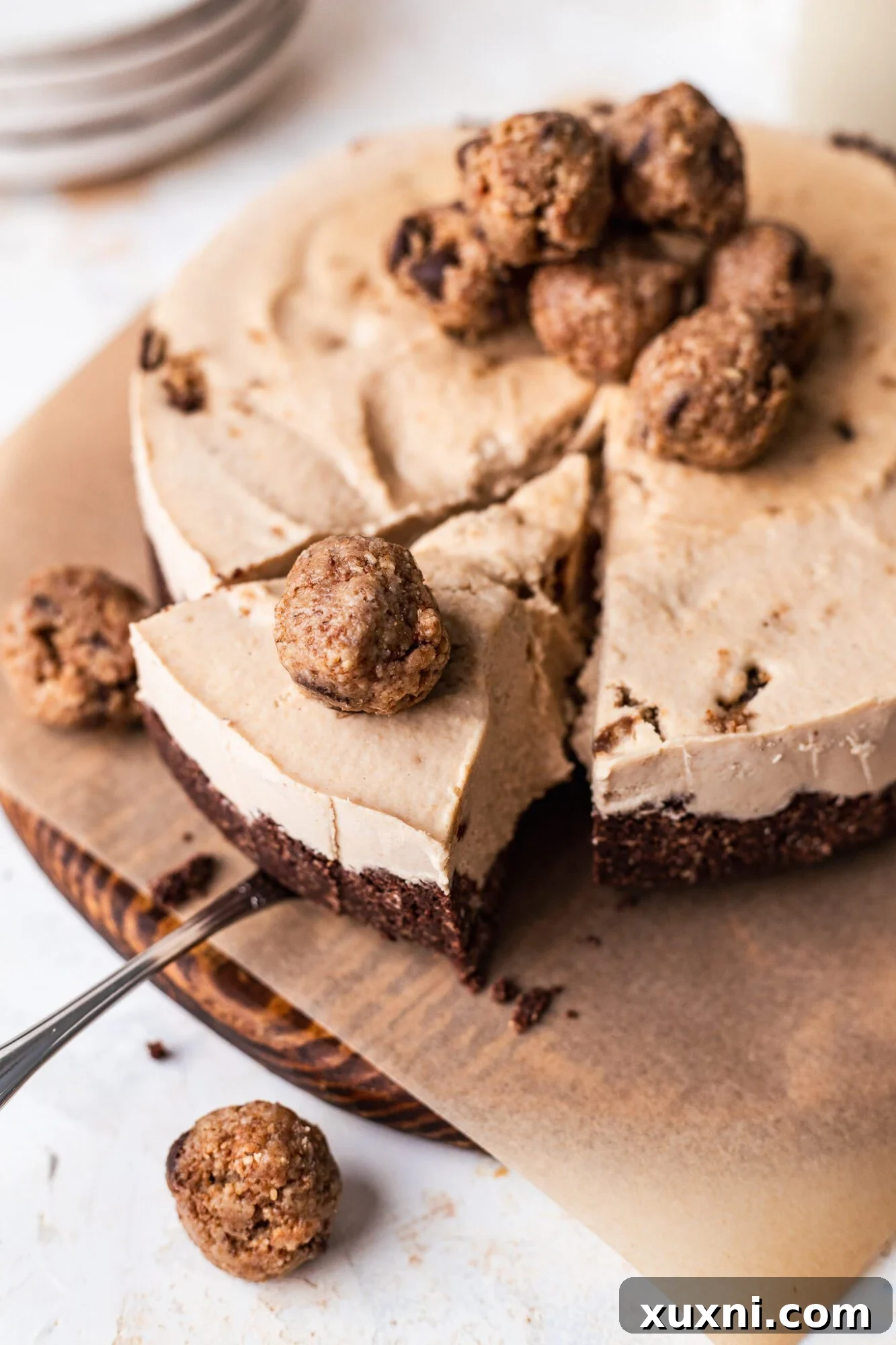 Serving slice of vegan cookie dough cheesecake