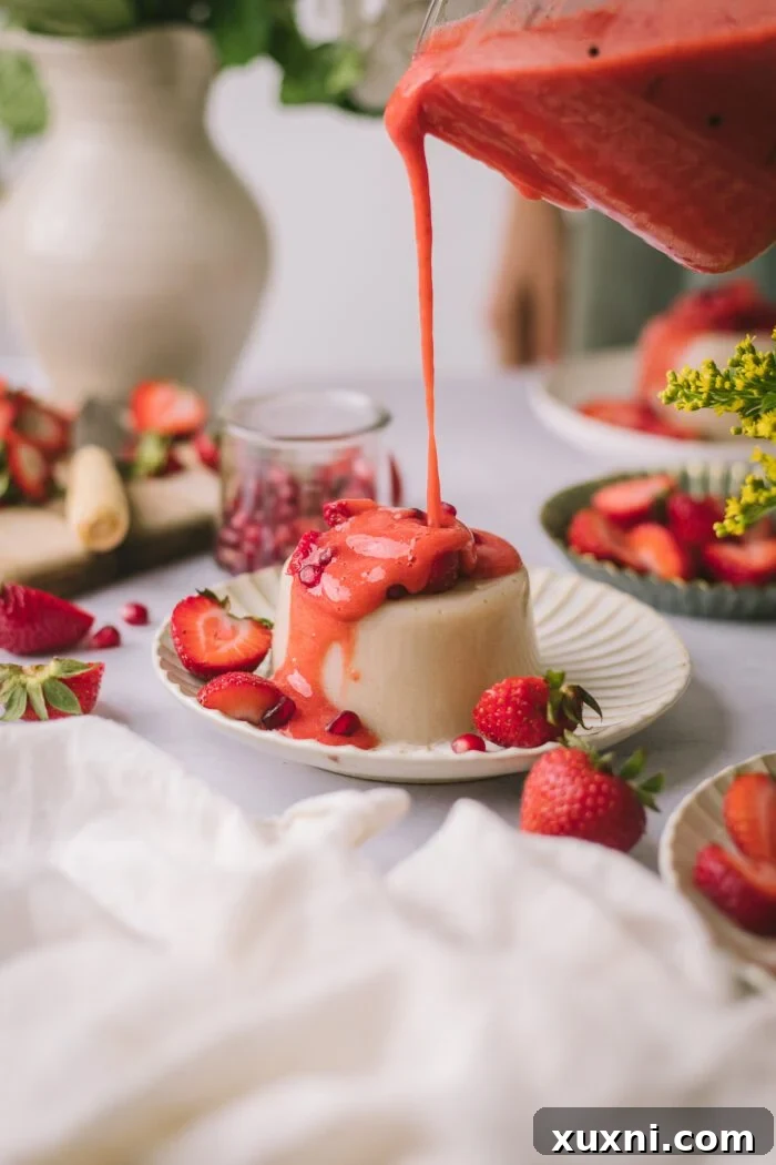 pouring strawberry coulis onto vegan panna cotta