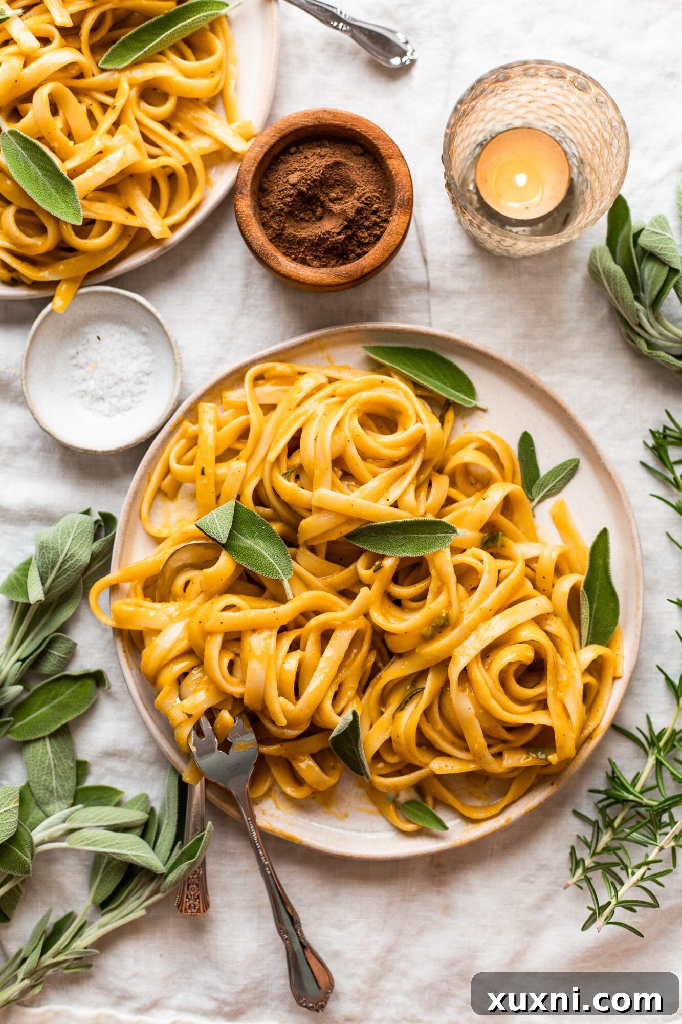 plate of creamy vegan pumpkin pasta garnished with fresh sage