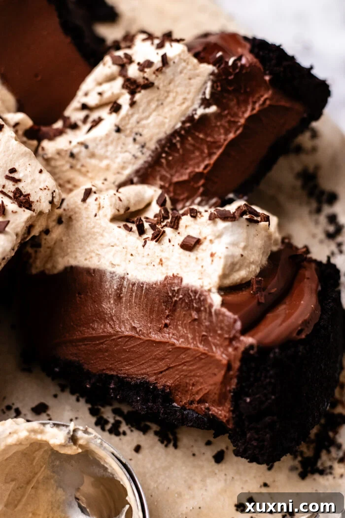 Close-up of a slice of no-bake vegan chocolate cheesecake, showing the layers of crust, filling, and creamy topping