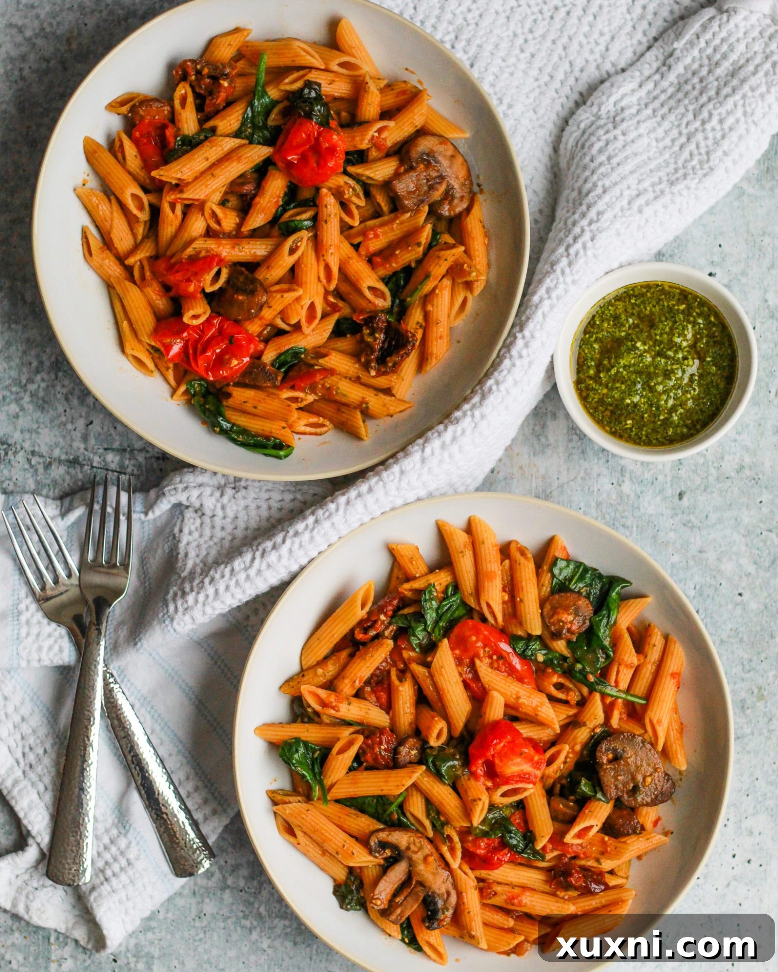 Delicious bowl of vibrant vegan sun-dried tomato pesto pasta, garnished with fresh basil, ready to be enjoyed as a healthy weeknight meal or part of a meal prep plan.
