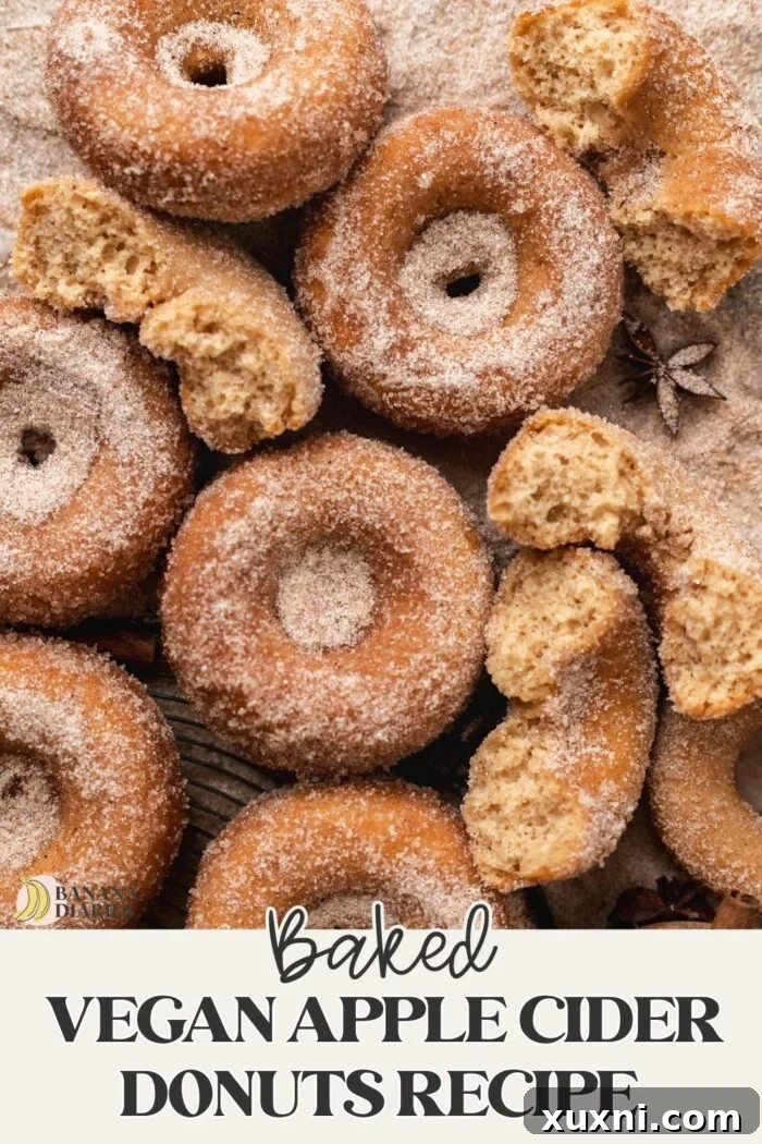Pinterest pin for One Bowl Baked Vegan Apple Cider Donuts Recipe, featuring a stack of glazed donuts