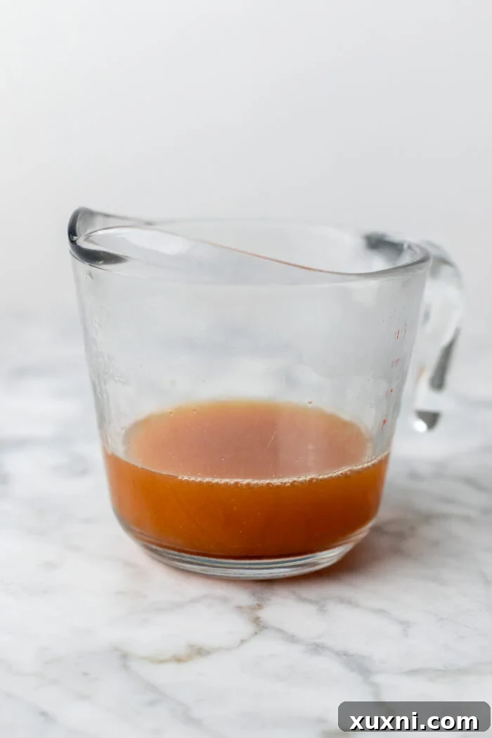 apple cider simmering in a saucepan, being reduced to concentrate its flavor