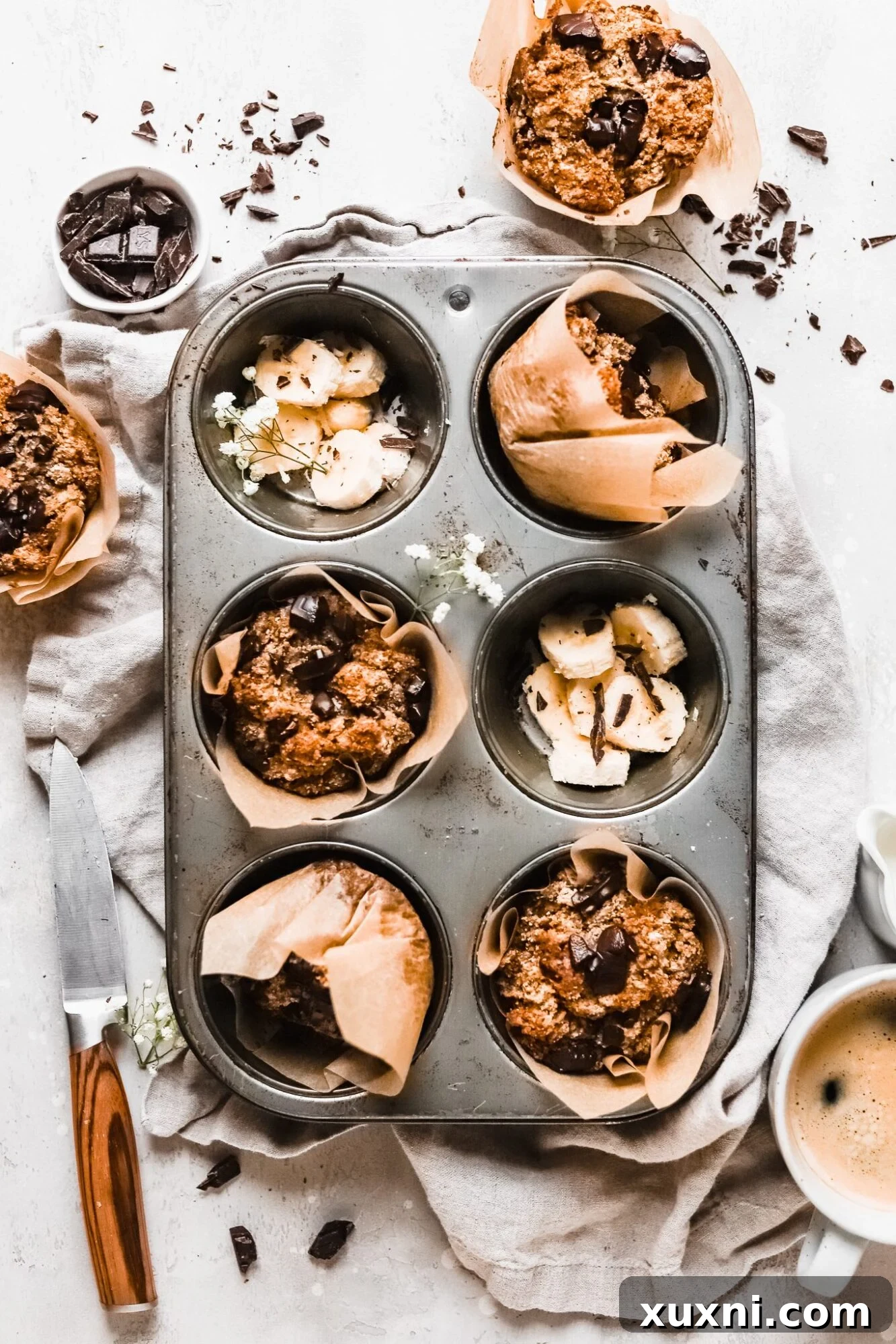 Freshly baked Paleo chocolate chip banana muffins in a muffin tin, golden brown and tempting.